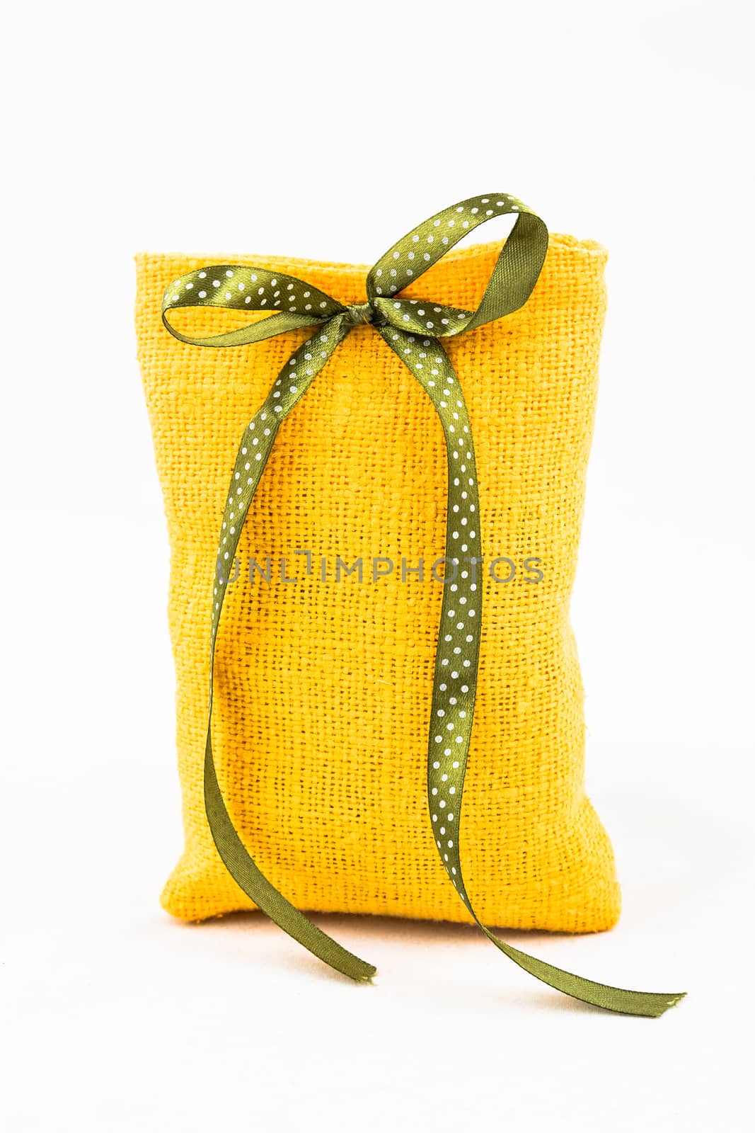 Decorative textile sachet pouch with a ribbon and bow on white background