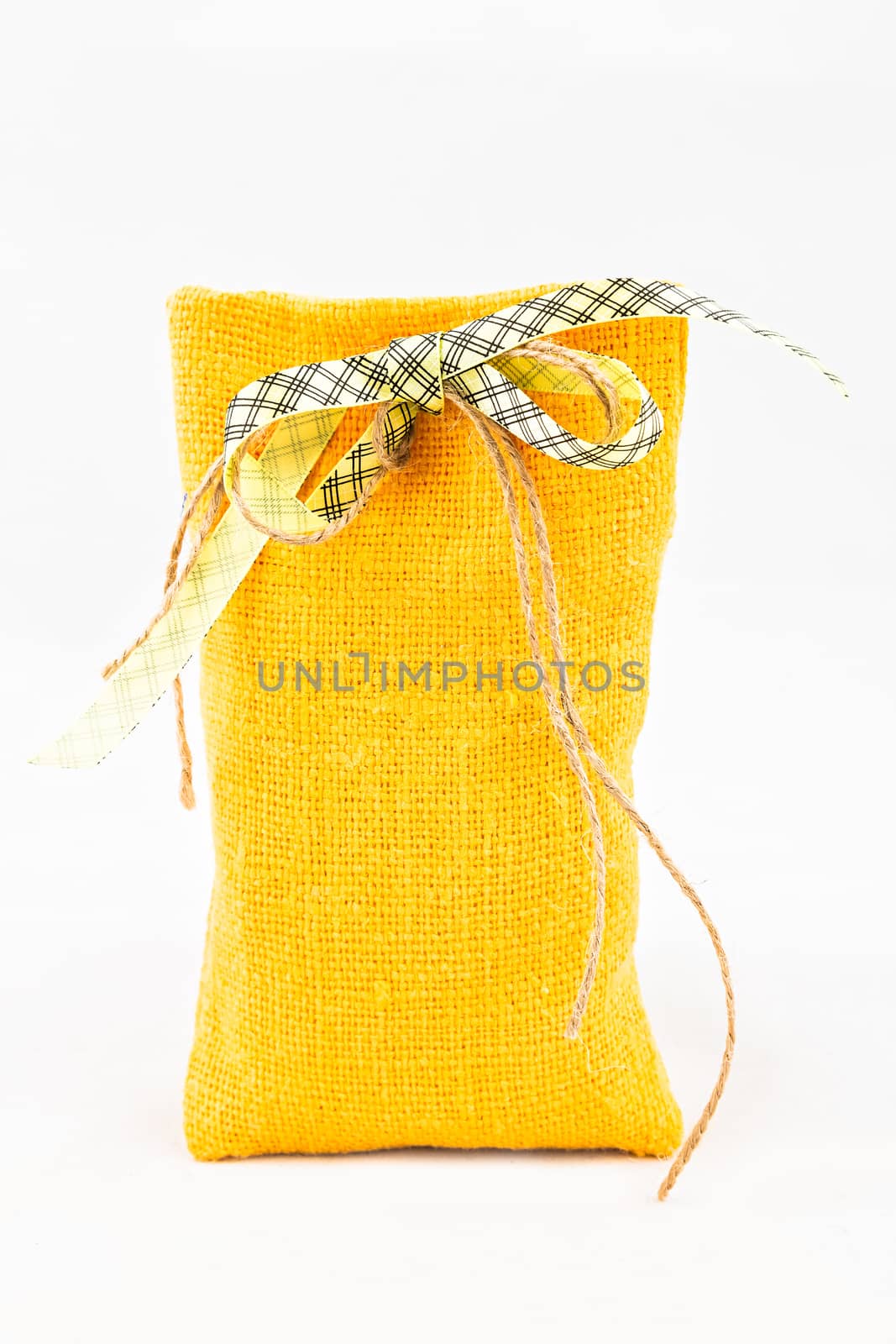 Decorative textile sachet pouch with a ribbon and bow on white background