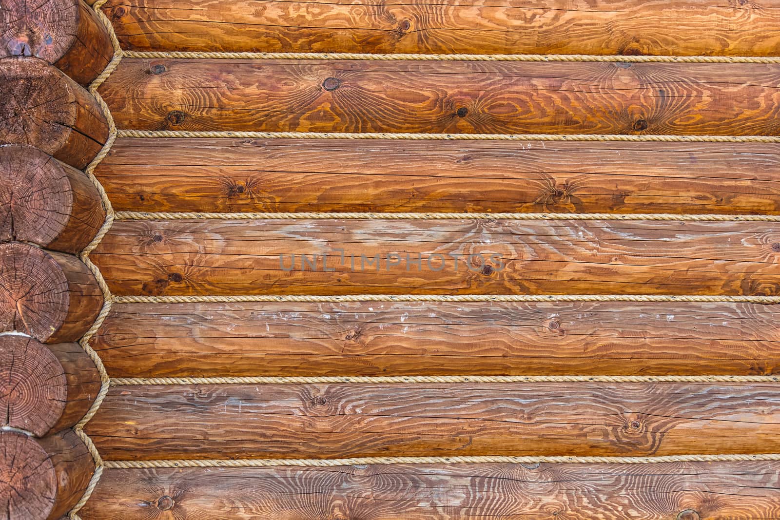 Wooden logs wall with rope of rural house background