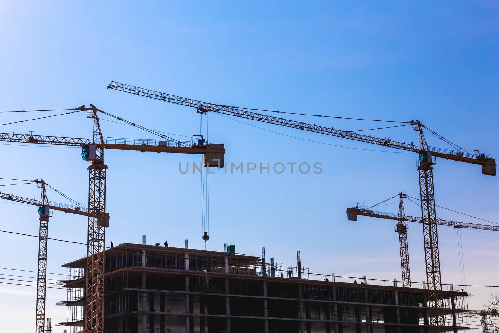 Construction cranes on building site on sky background