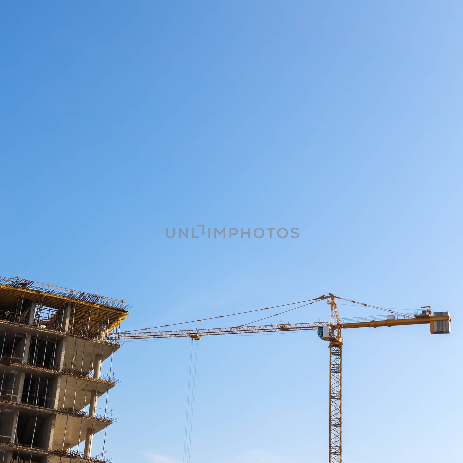 Construction crane on building site on sky background