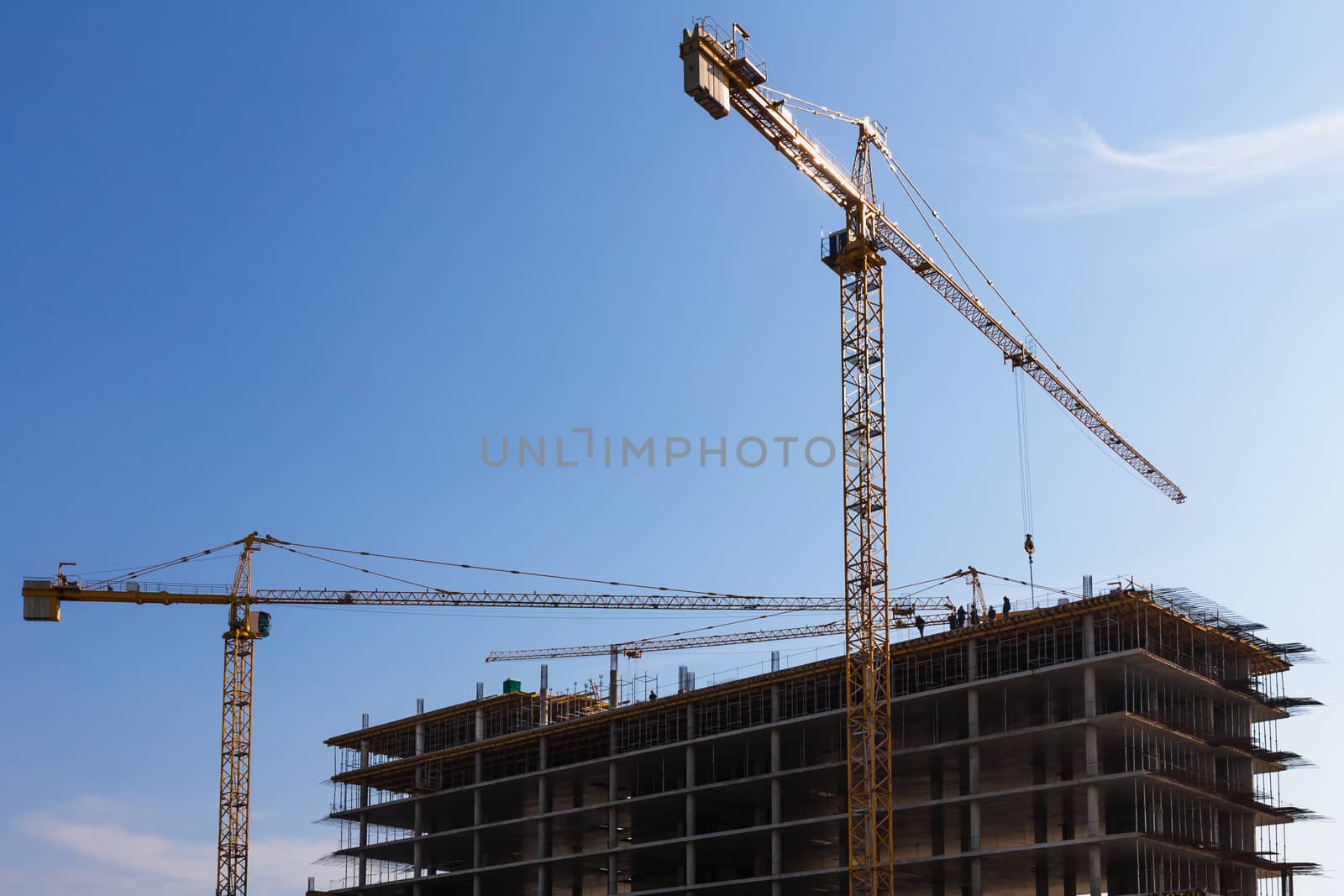 Construction cranes on building site on sky background