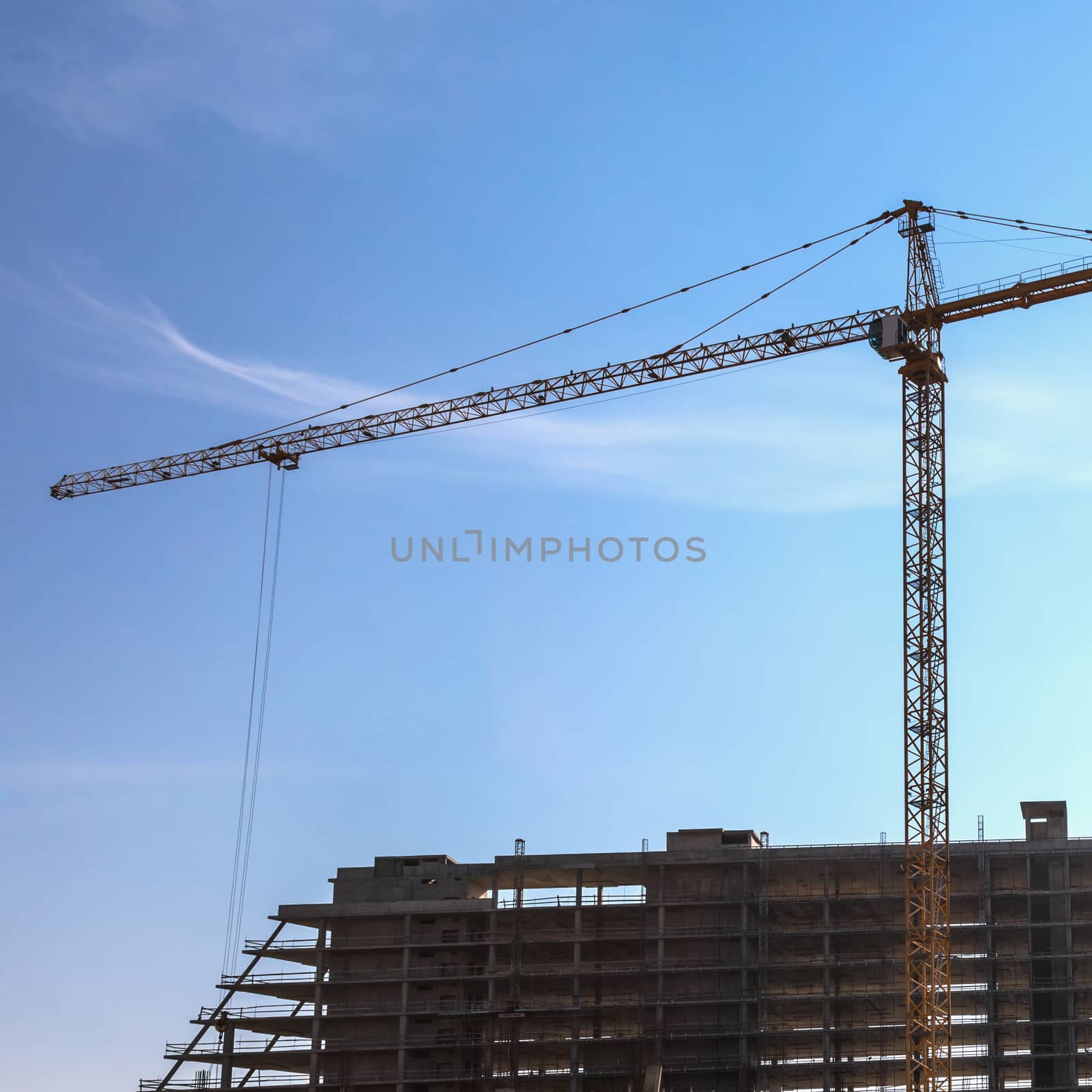 Construction crane on building site on sky background