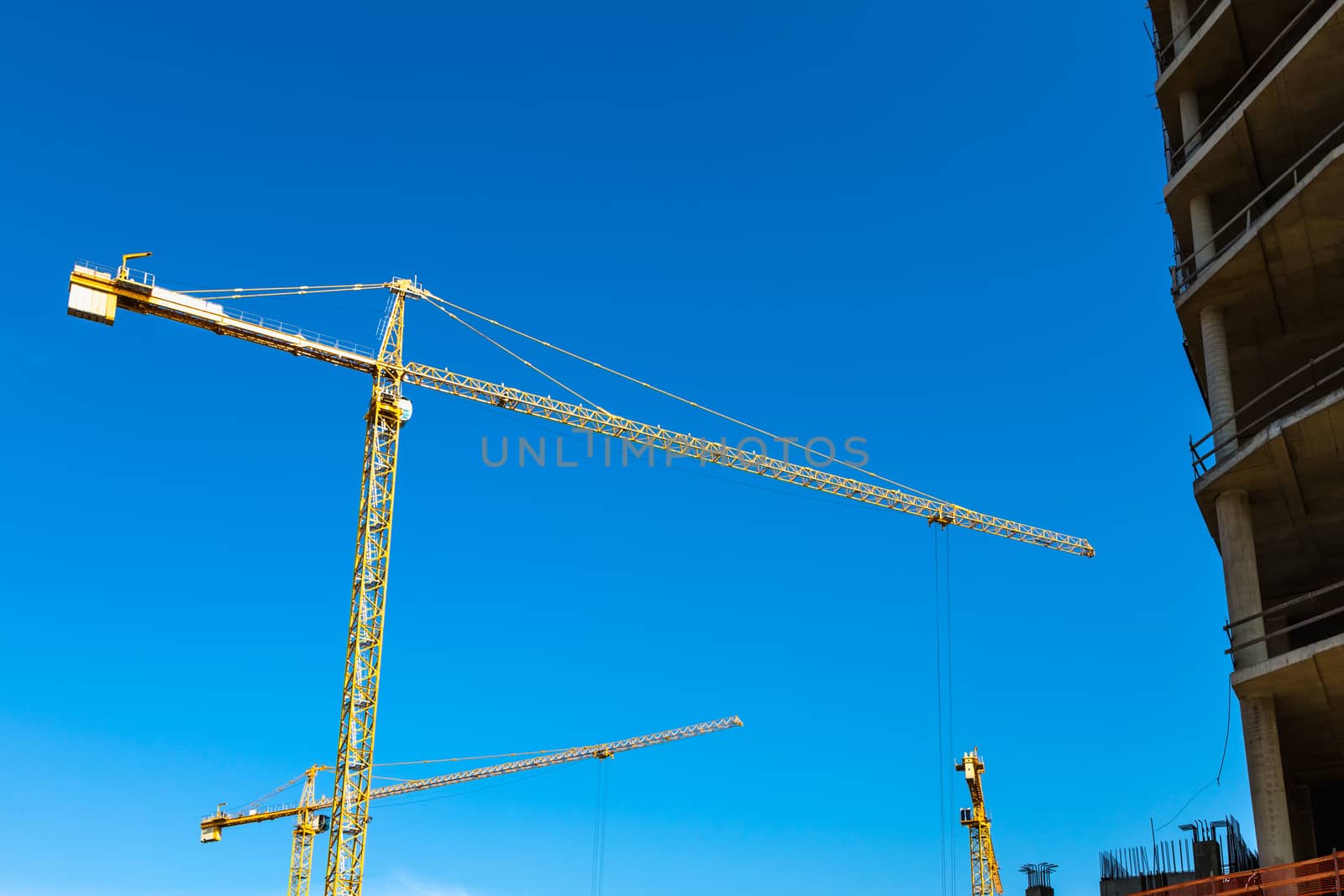 Construction cranes on building site on sky background