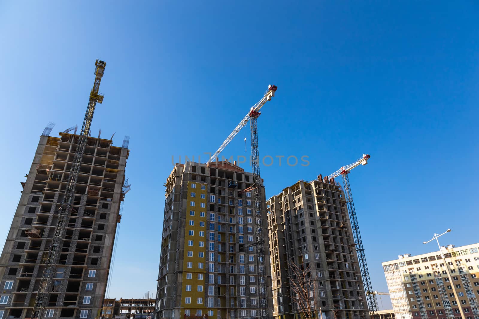 Construction cranes on building site on sky background
