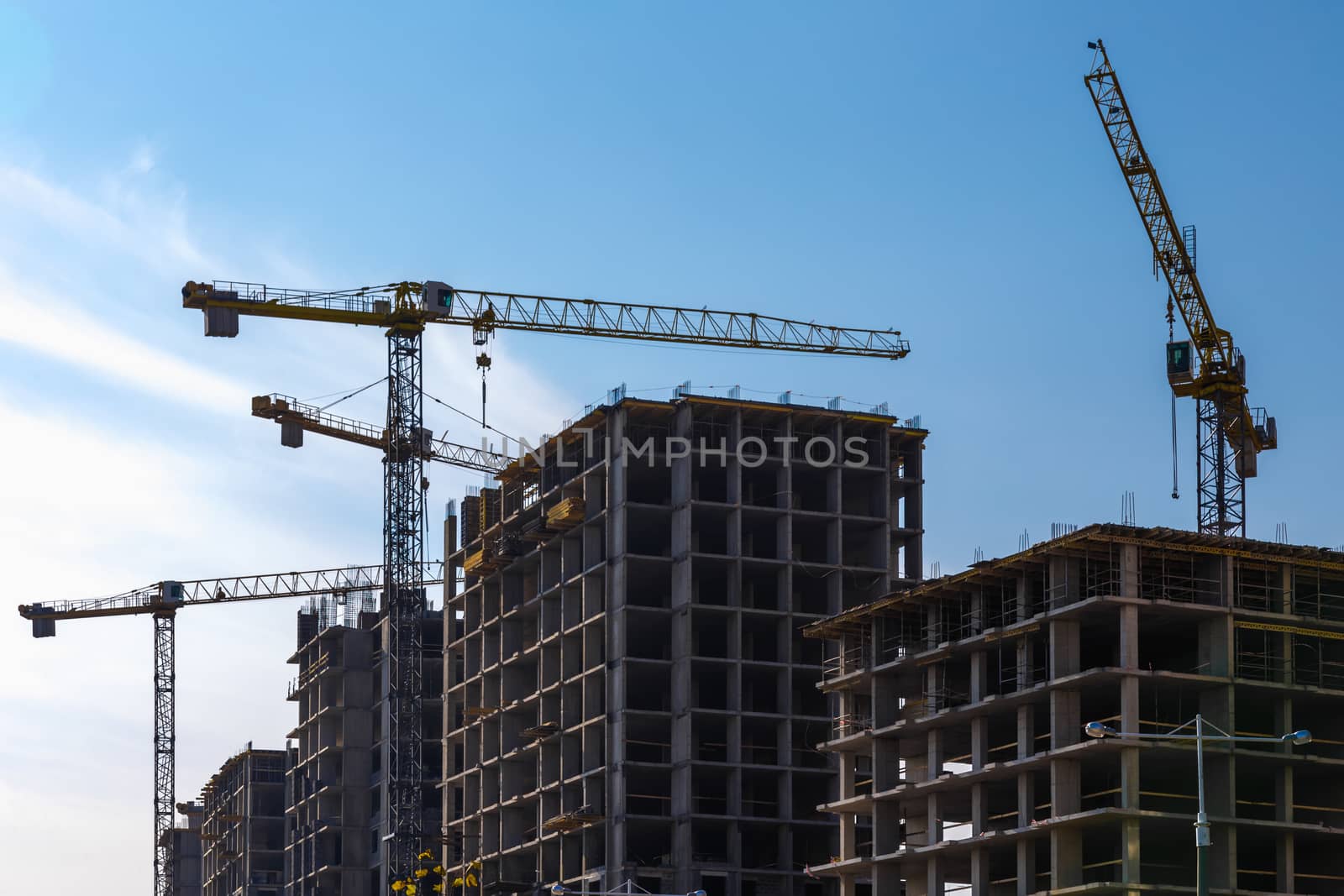 Construction cranes on building site on sky background