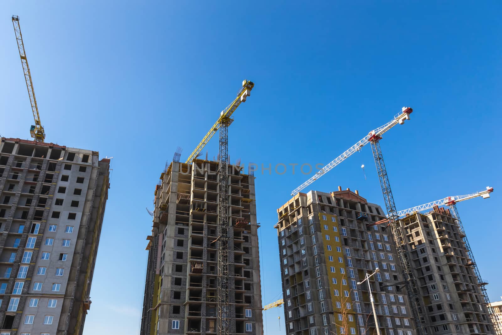 Construction cranes on building site on sky background