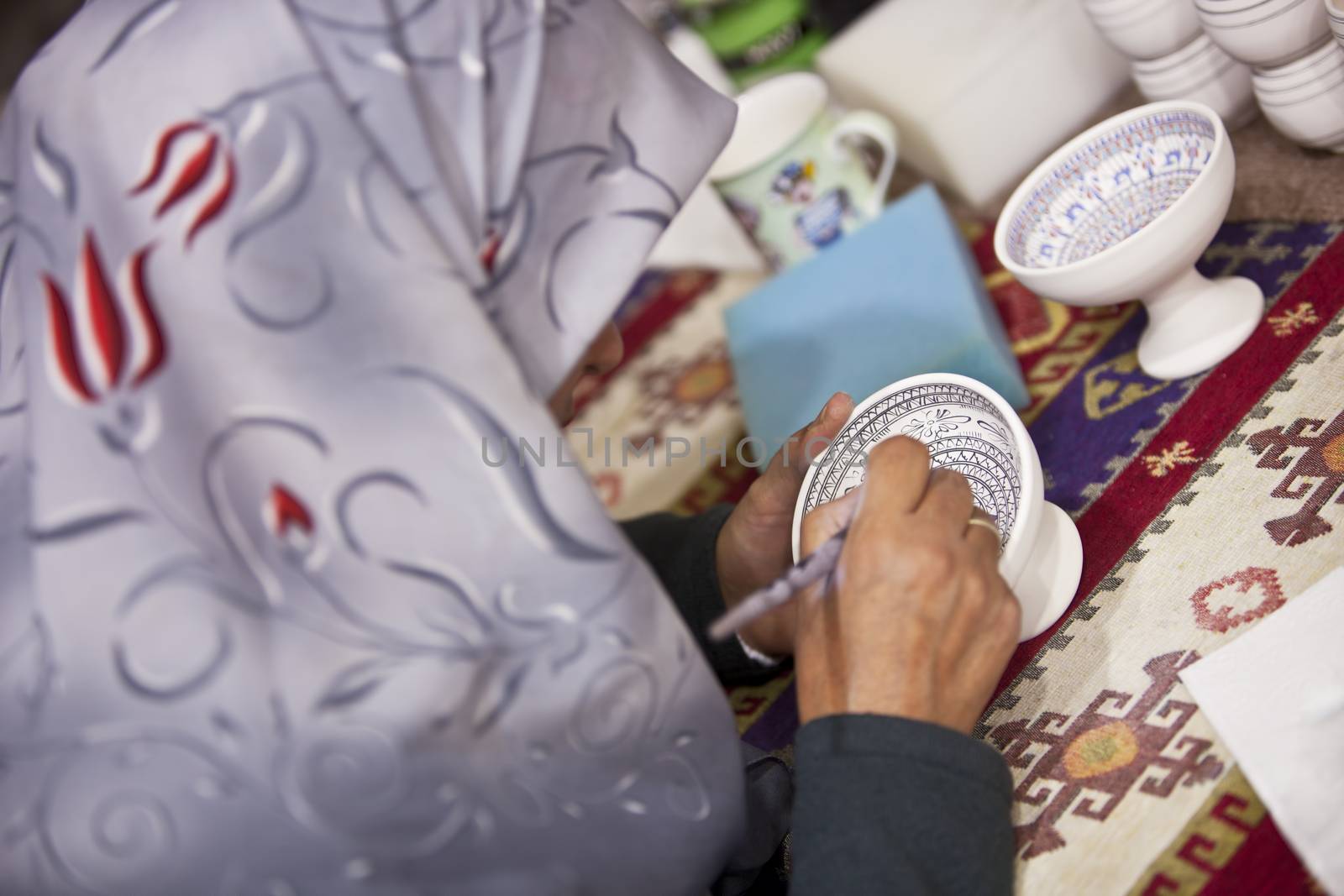 CAPPADOCIA, TURKEY – APRIL 17: Woman decorates a ceramic bowl with designs typical to the region on April 17, 2012 in Cappadocia, Turkey.