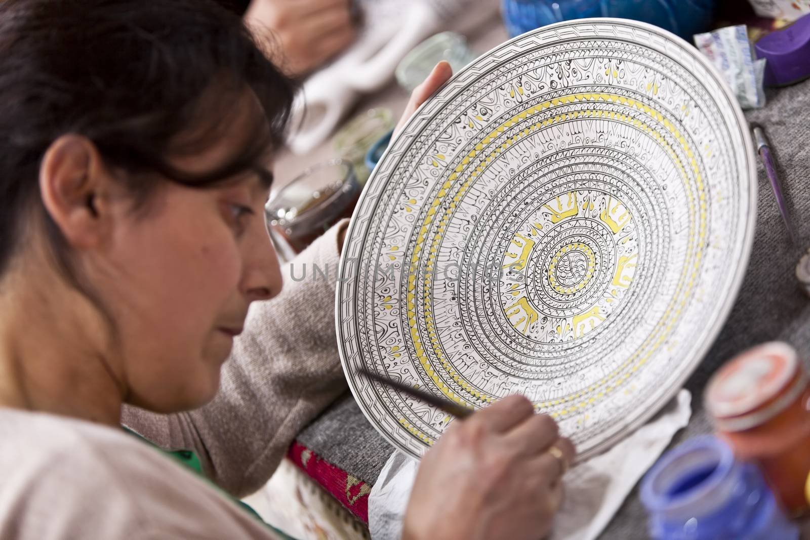 CAPPADOCIA, TURKEY – APRIL 17: Artist adds detail to a ceramic bowl with animal design patternon April 17, 2012 in Cappadocia, Turkey.