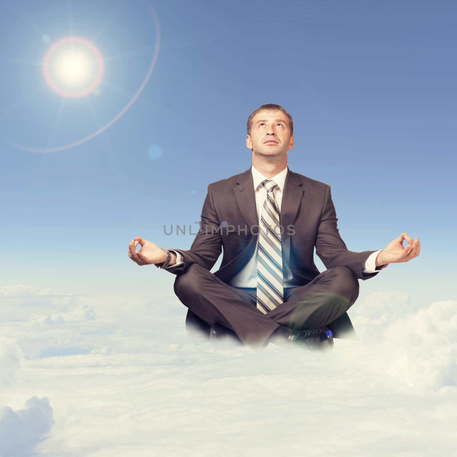 Businessman sitting in lotus position on cloud by cherezoff