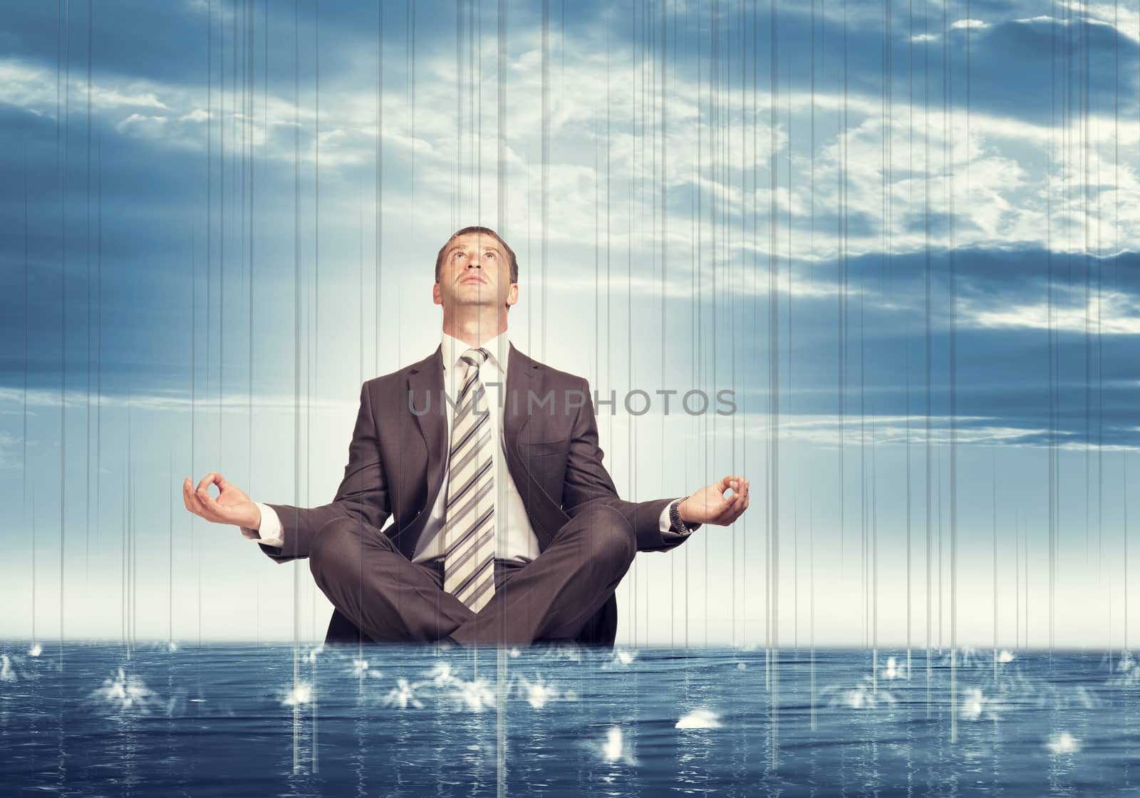 Businessman sitting in lotus position on water by cherezoff