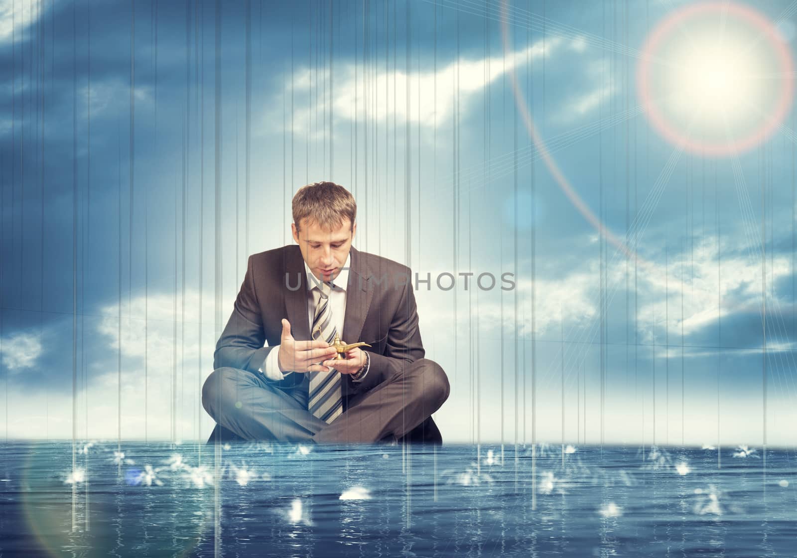 Businessman sitting in lotus position on water in sea and looking at oil lamp