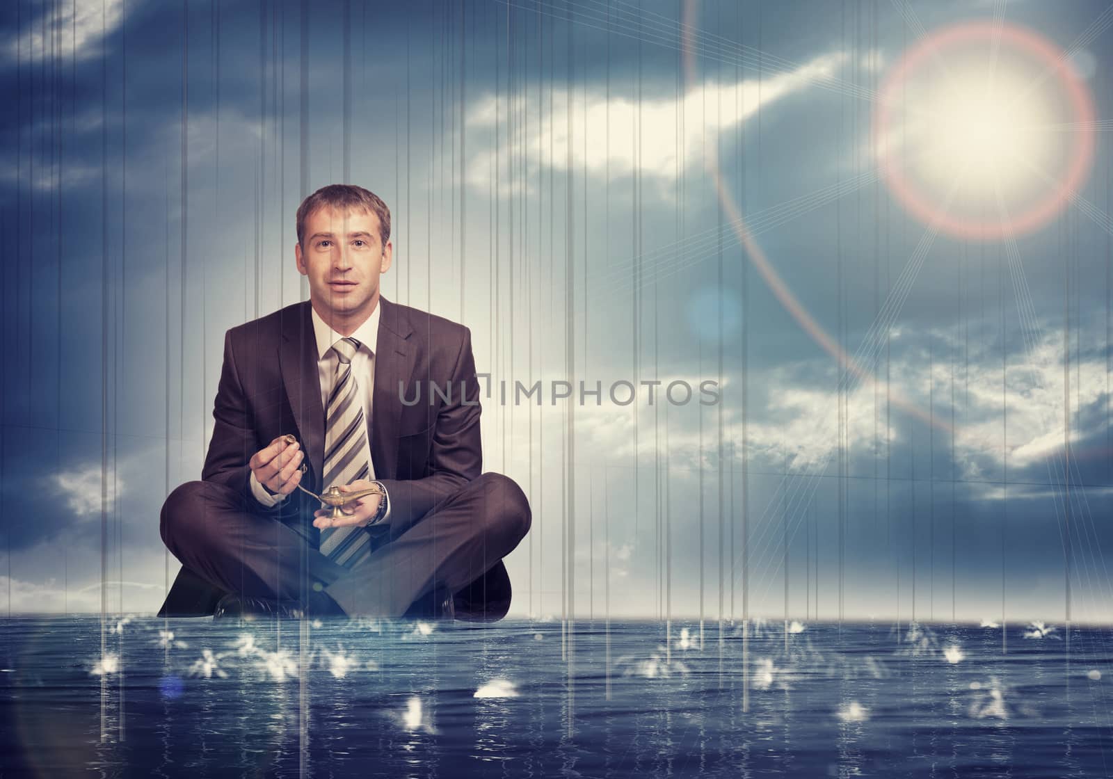 Businessman sitting in lotus position on water in sea and looking at camera