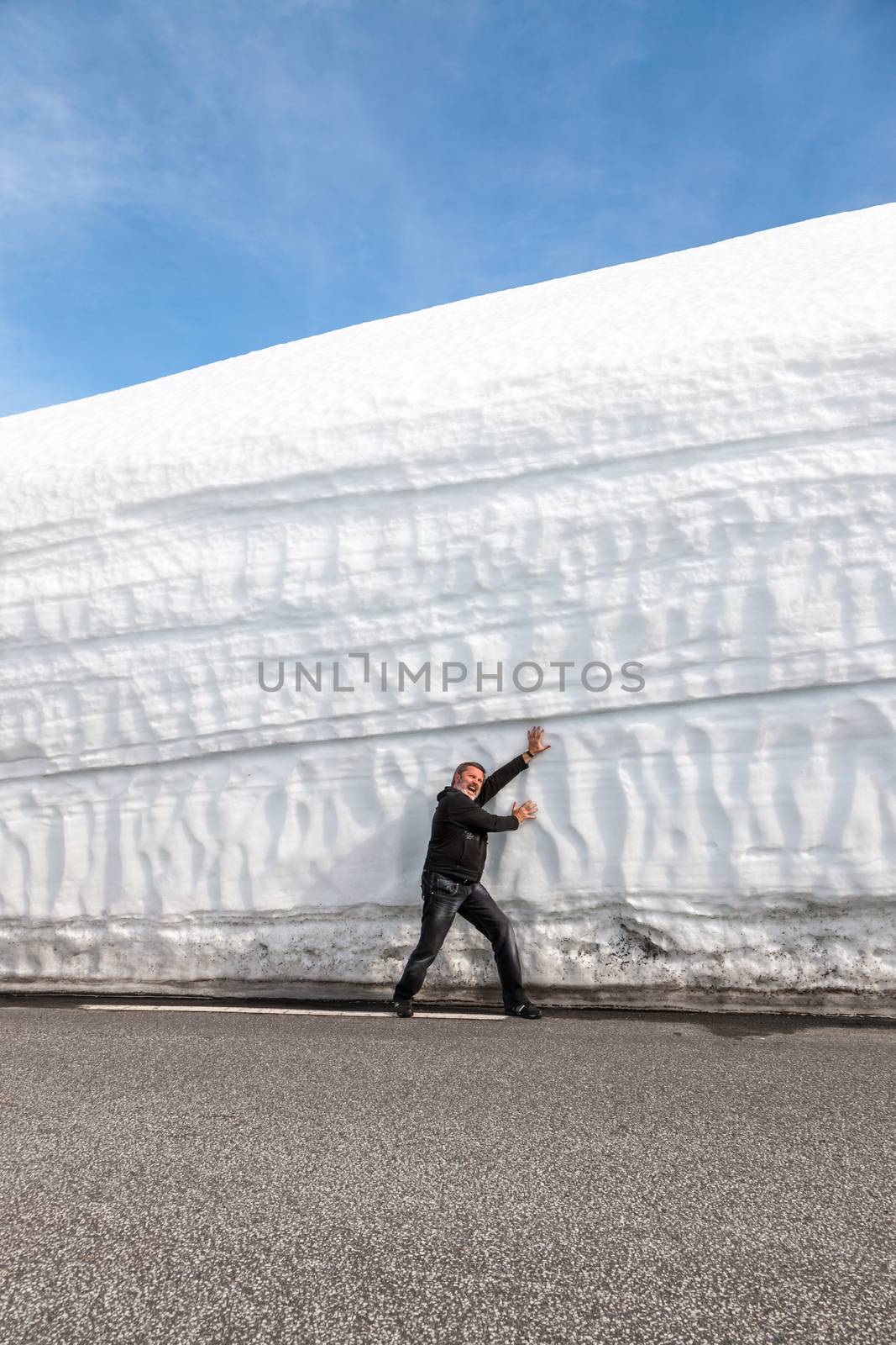 man on the highway along the snow wall. Norway in the spring