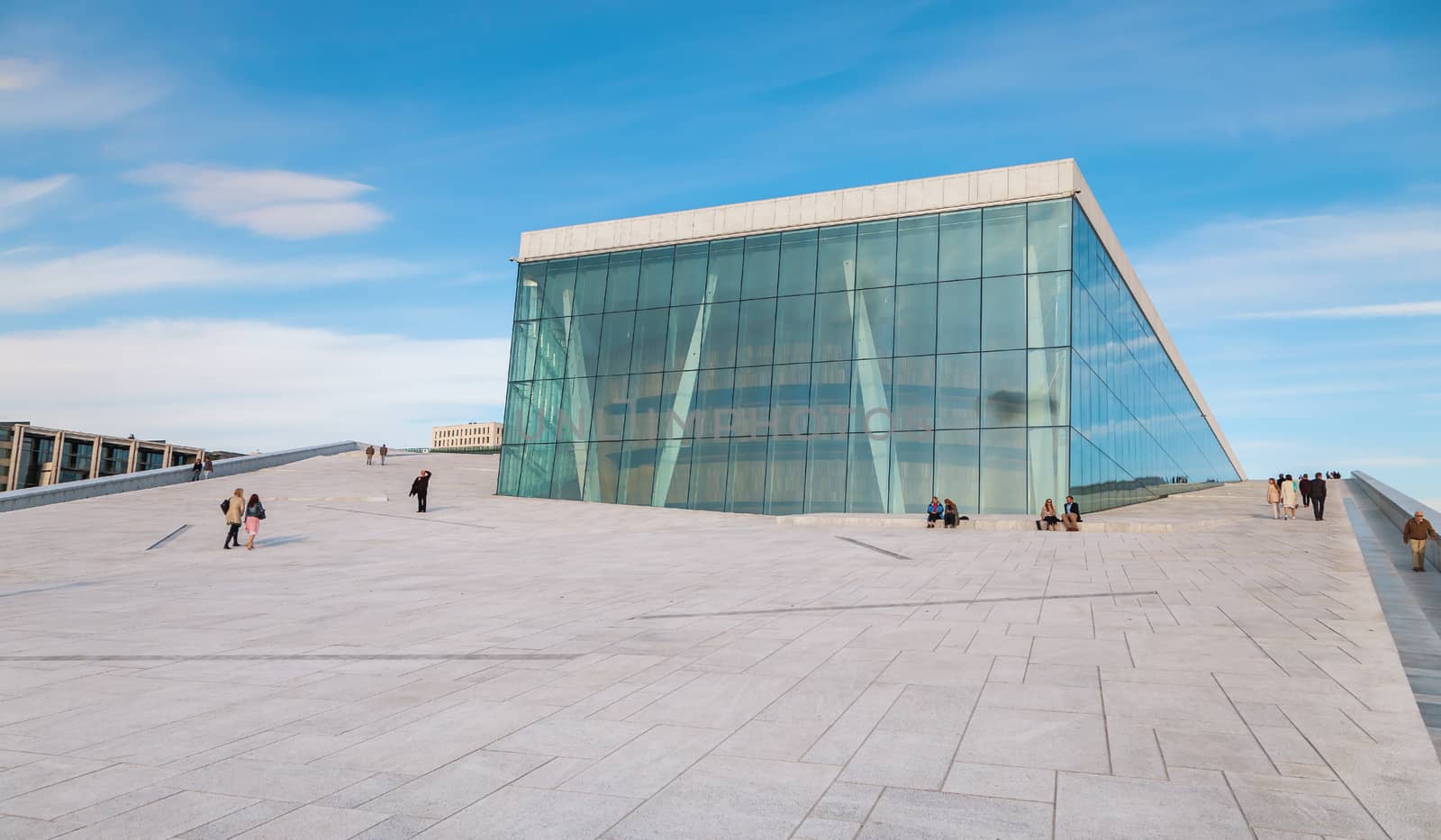 People walking on the roof of the Oslo Opera House. The Oslo Opera House is home The Norwegian National Opera and Ballet, and the National Opera Theatre. by master1305