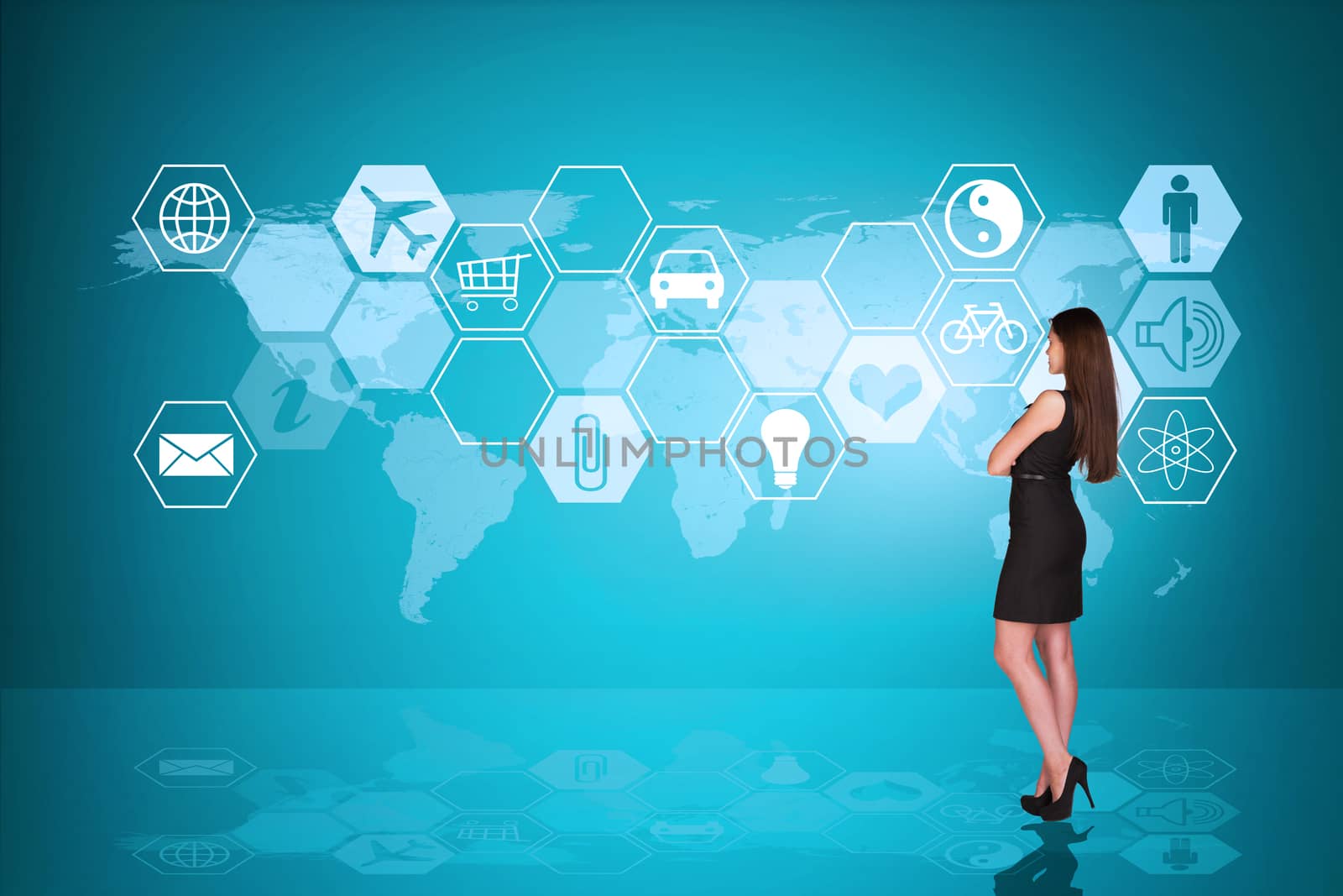Businesslady half-turned in black dress with crossed arms in front of holographic screen with icons, back view