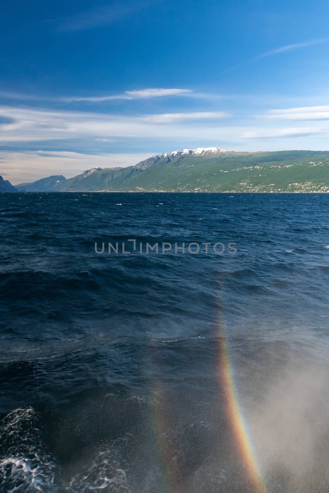 rainbow on a lake Garda with mountains as background. Garda, Italy