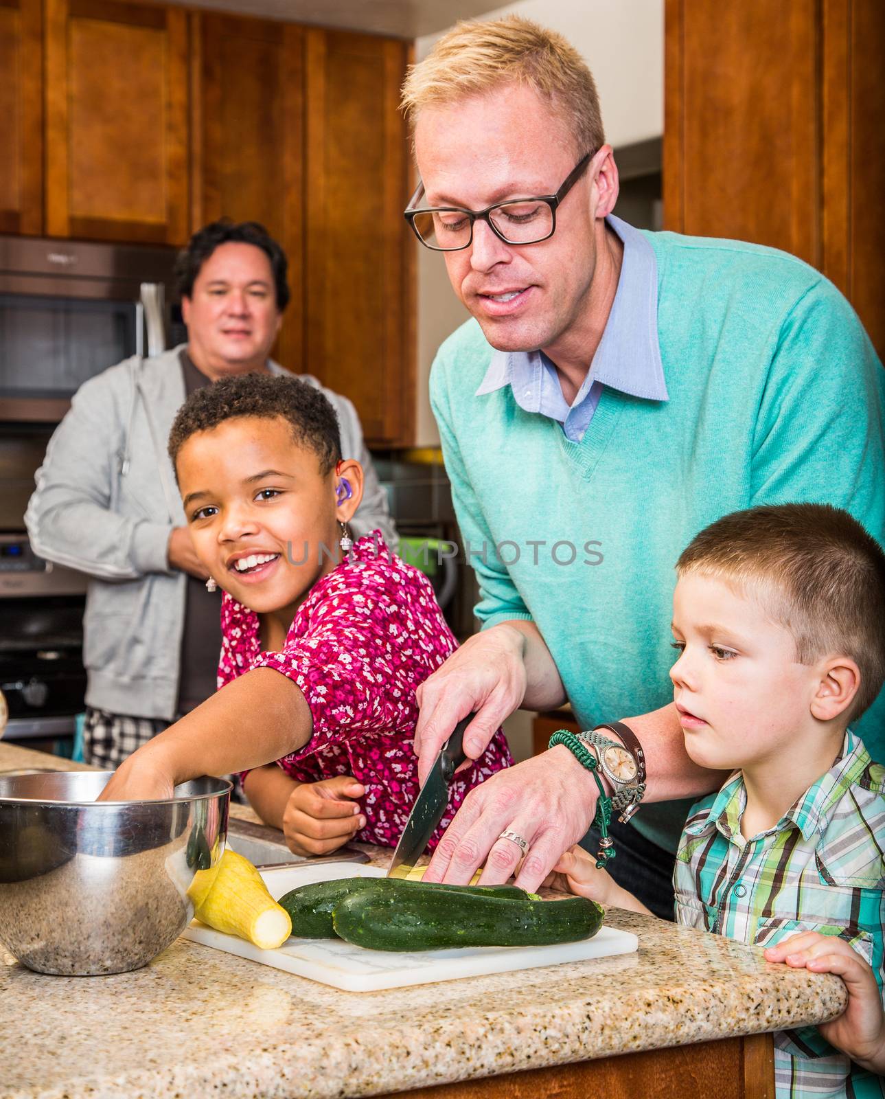 Happy gay fathers with their children in the kitchen
