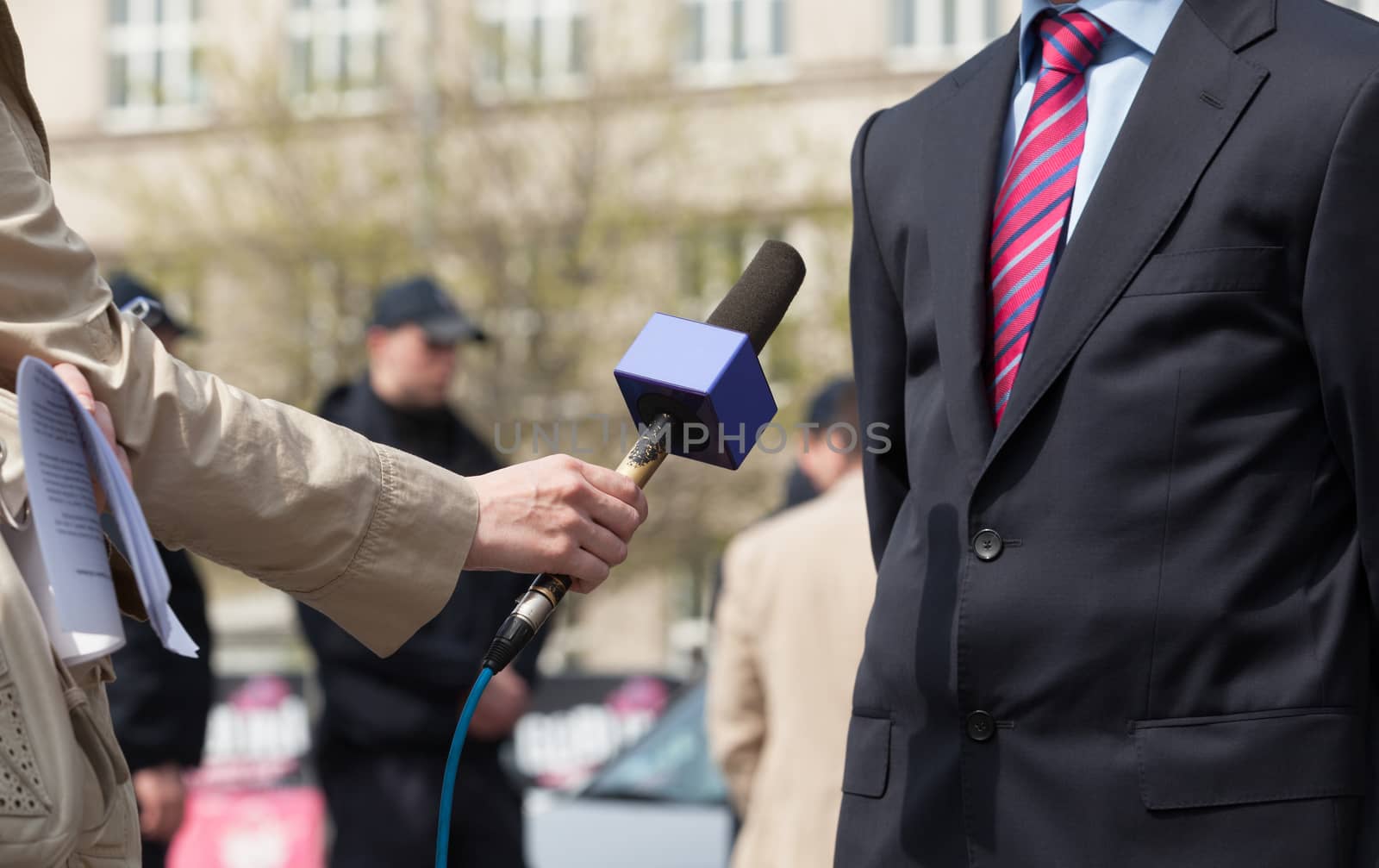 Journalist making media interview with unrecognizable politician or businessman