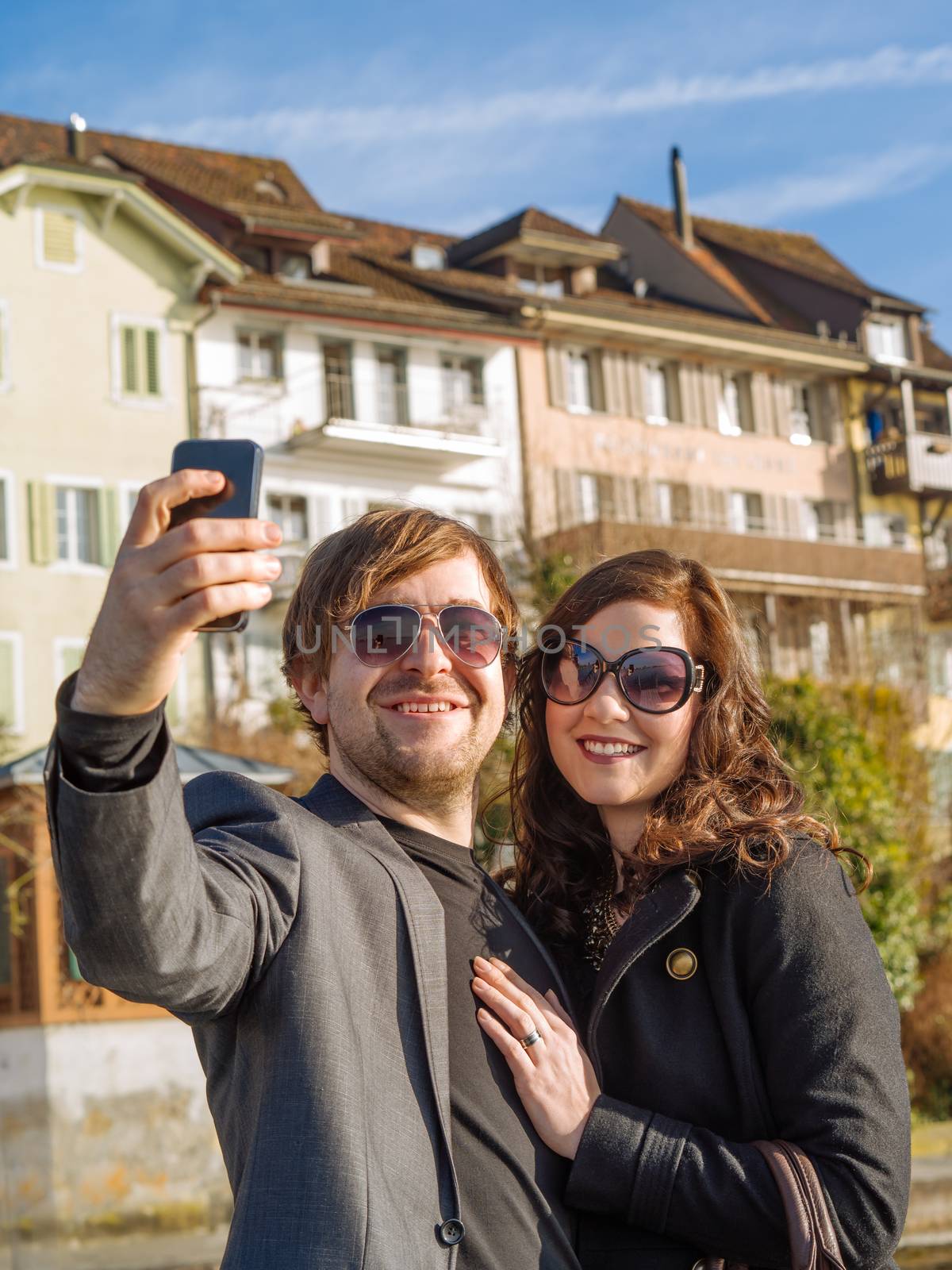 Photo of a happy couple taking a selfie while traveling in the Swiss city of Zug.
