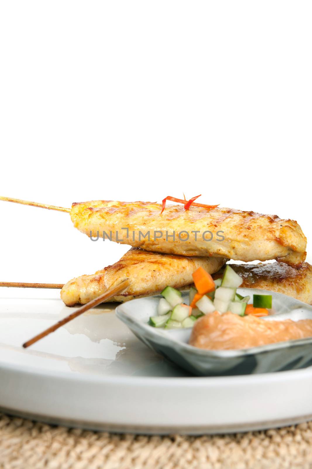 Asian style chicken satay barbecued chicken on skewers with peanut dipping sauce.