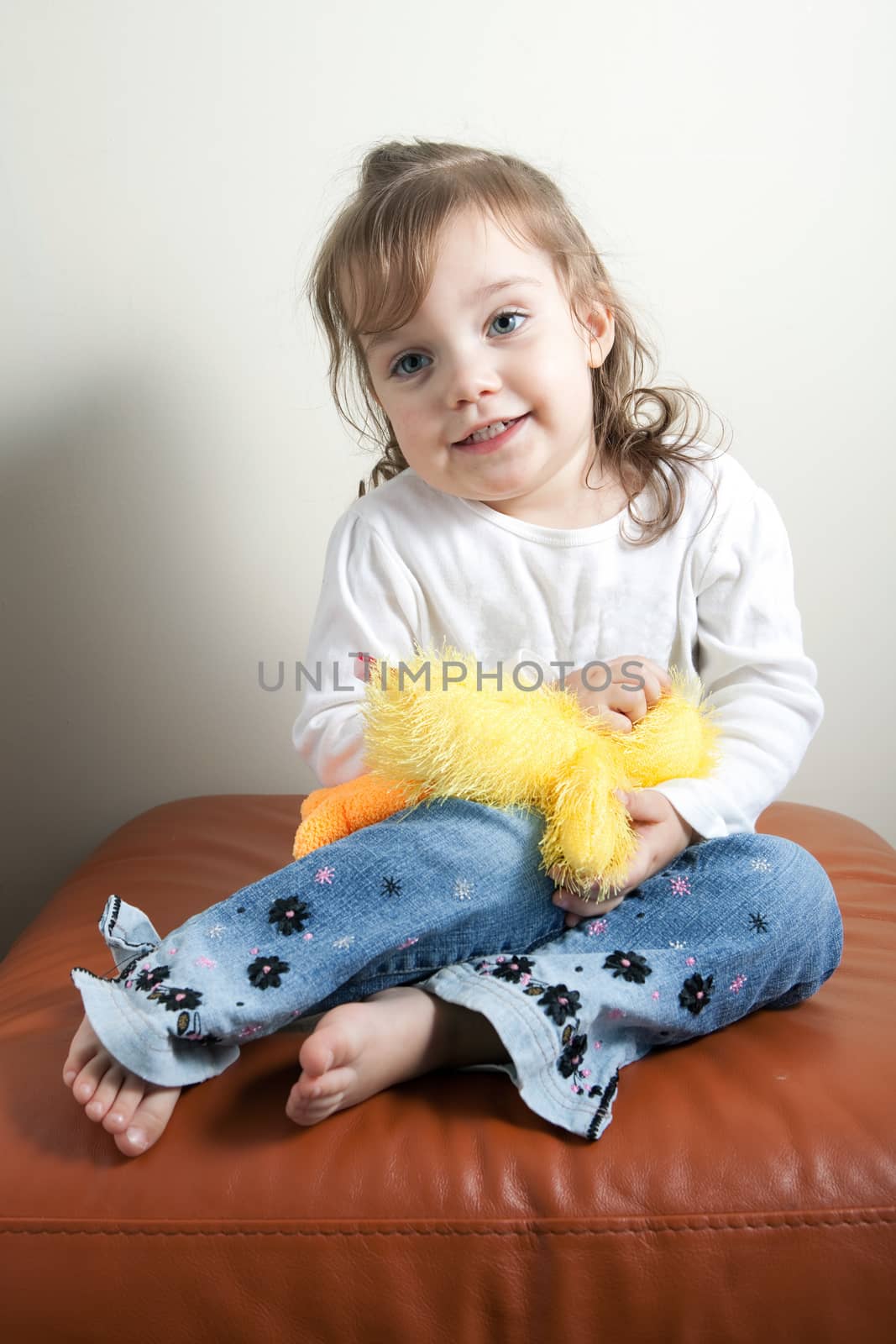 Portrait of a little girl holding her favorite teddy bear in black and white.