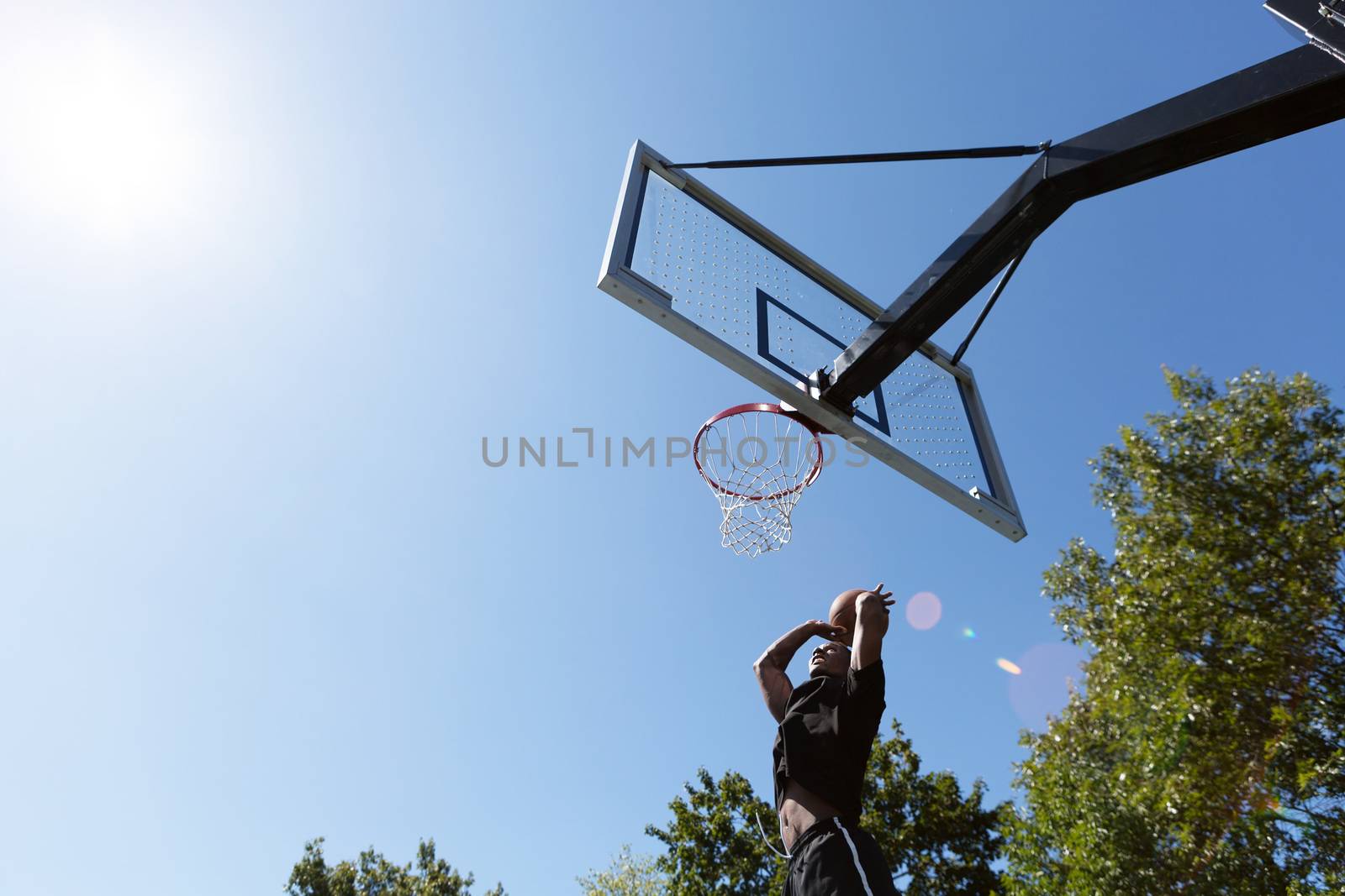 Young basketball player driving to the hoop for a high flying slam dunk.