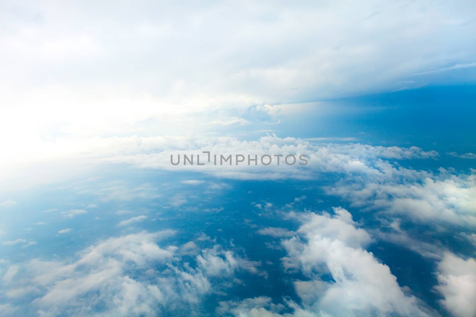 Aerial view of the blue skies and horizon with fluffy clouds and the earth below shot over Tennessee USA.