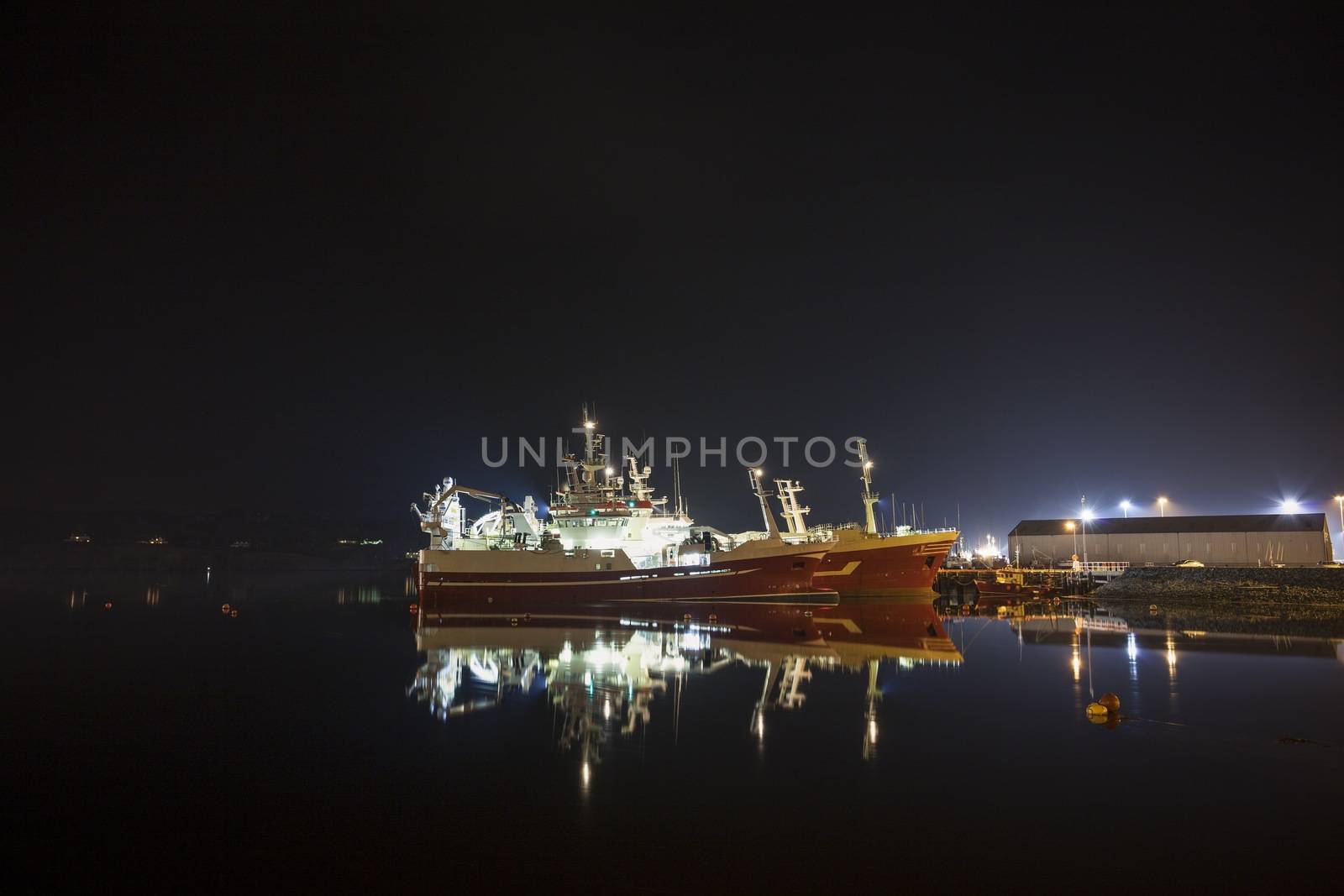 Fishing trawlers docked at Killybegs harbor at night time 