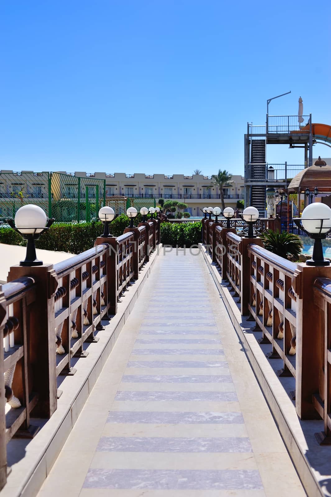 beautiful bridge with wooden railings and lamps.