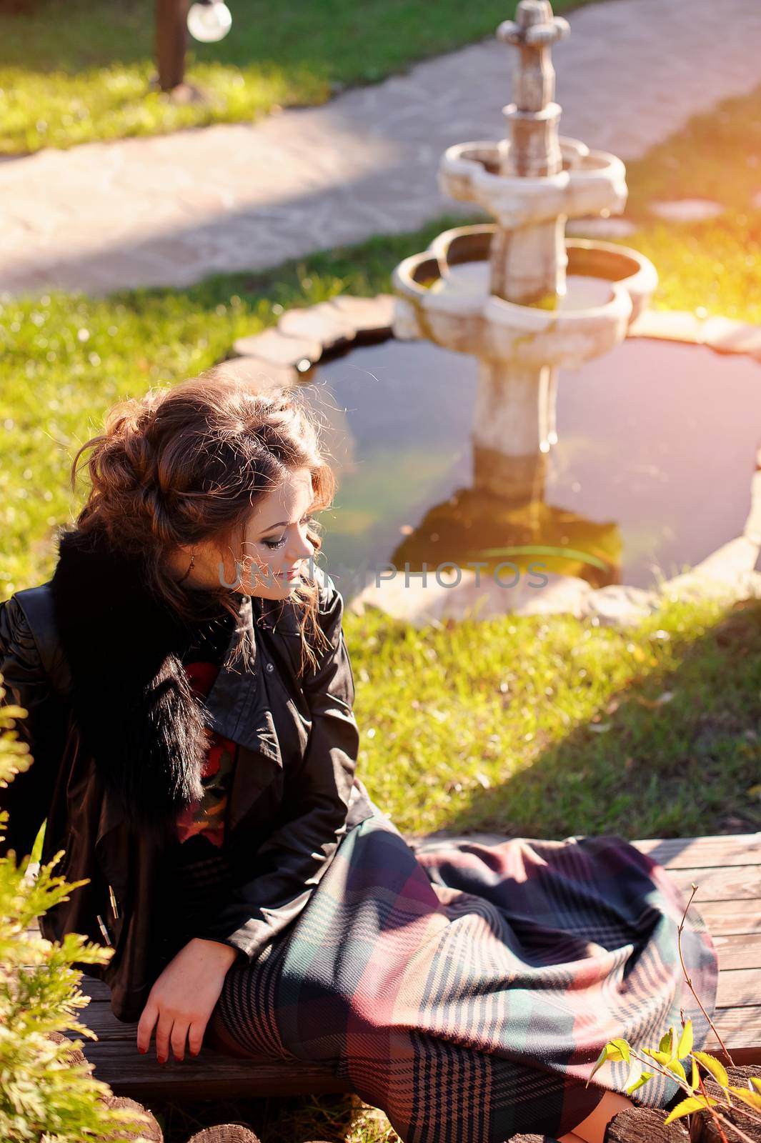 Beautiful girl sitting on the grass in the park.