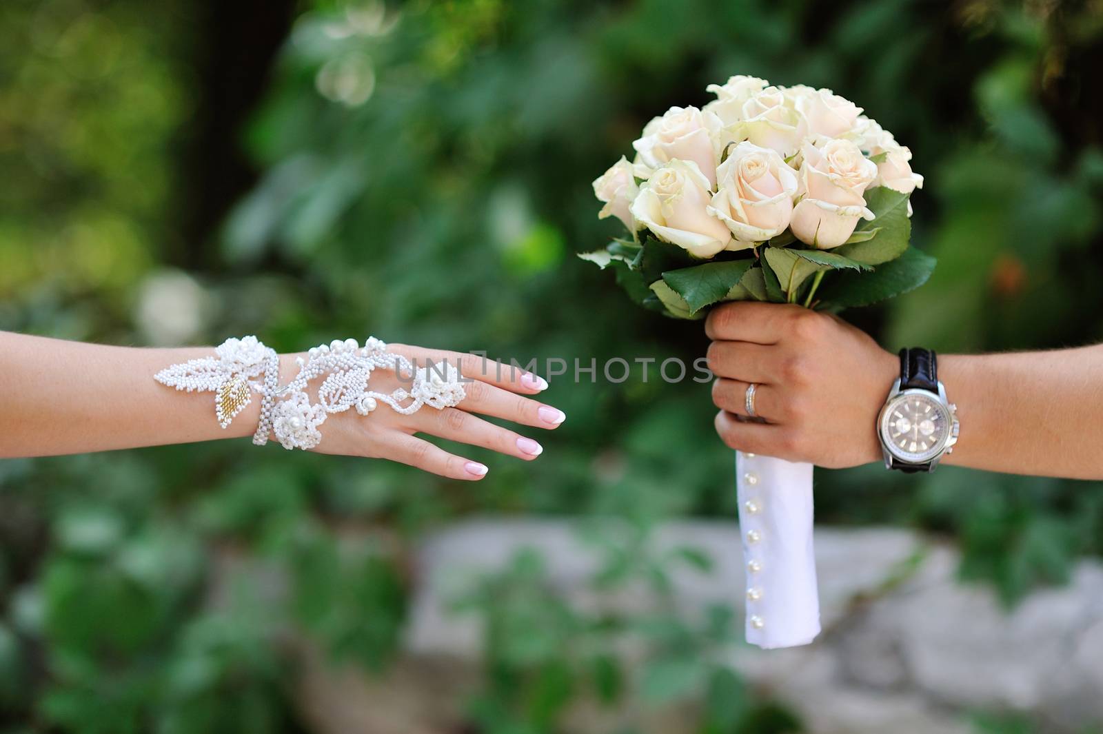 Groom transmits give bride wedding bouquet of white roses.