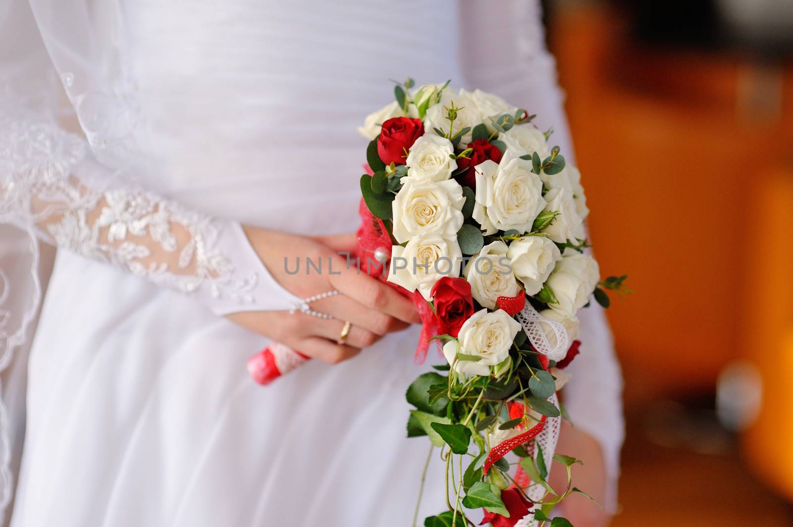 beautiful wedding bouquet with white rose at bride's hands.