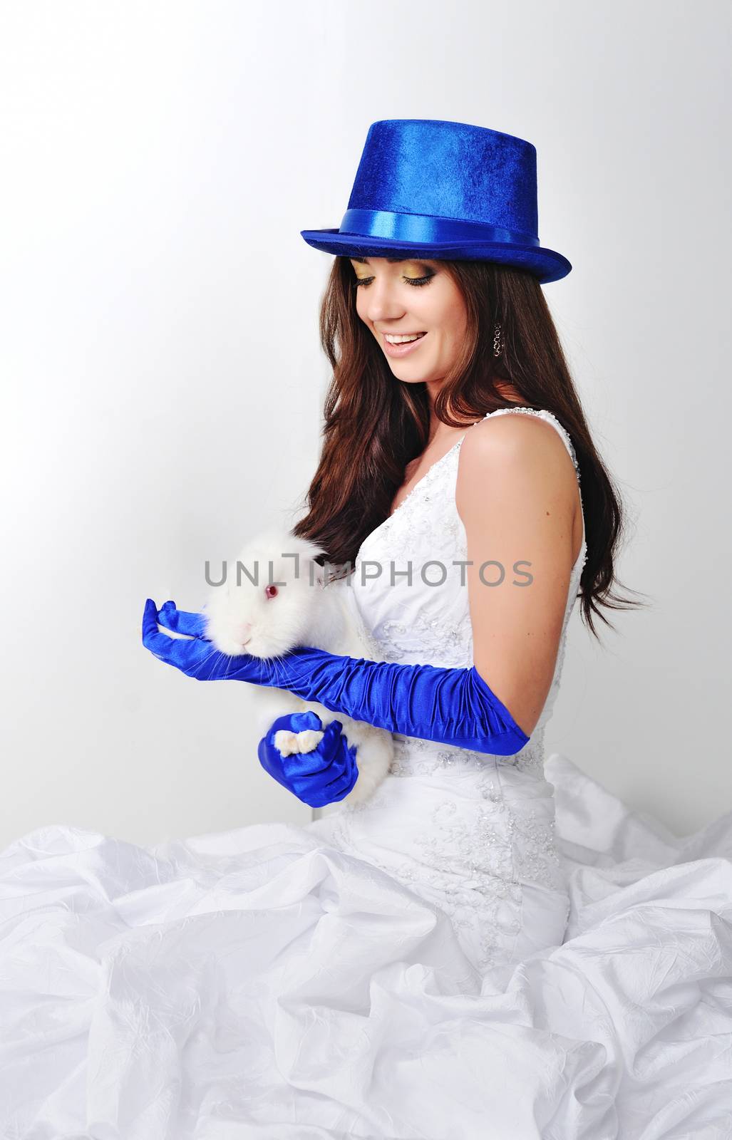 Bride with a rabbit in a blue hat and blue gloves.