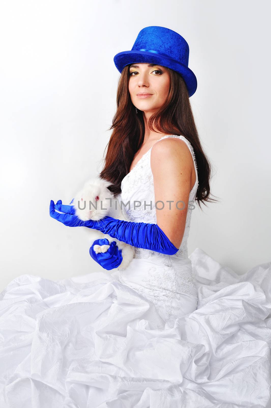 Beautiful girl in a white dress in a blue hat and gloves on a white background