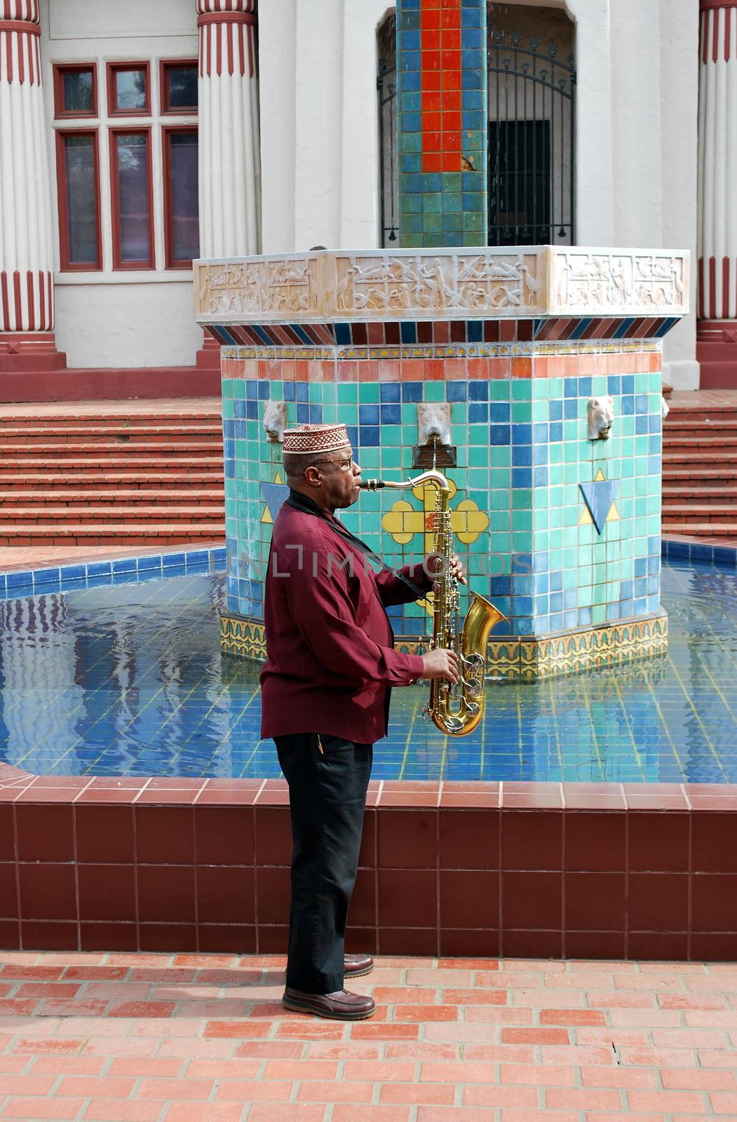 Muslim male jazz musician with his saxophone outdoors.