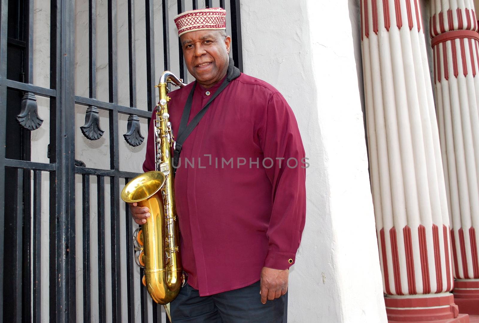 Muslim male jazz musician with his saxophone outdoors.