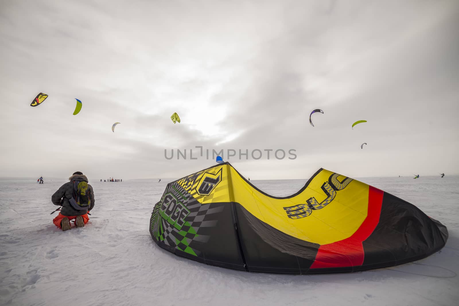 Kite surfer being pulled by his kite across the snow