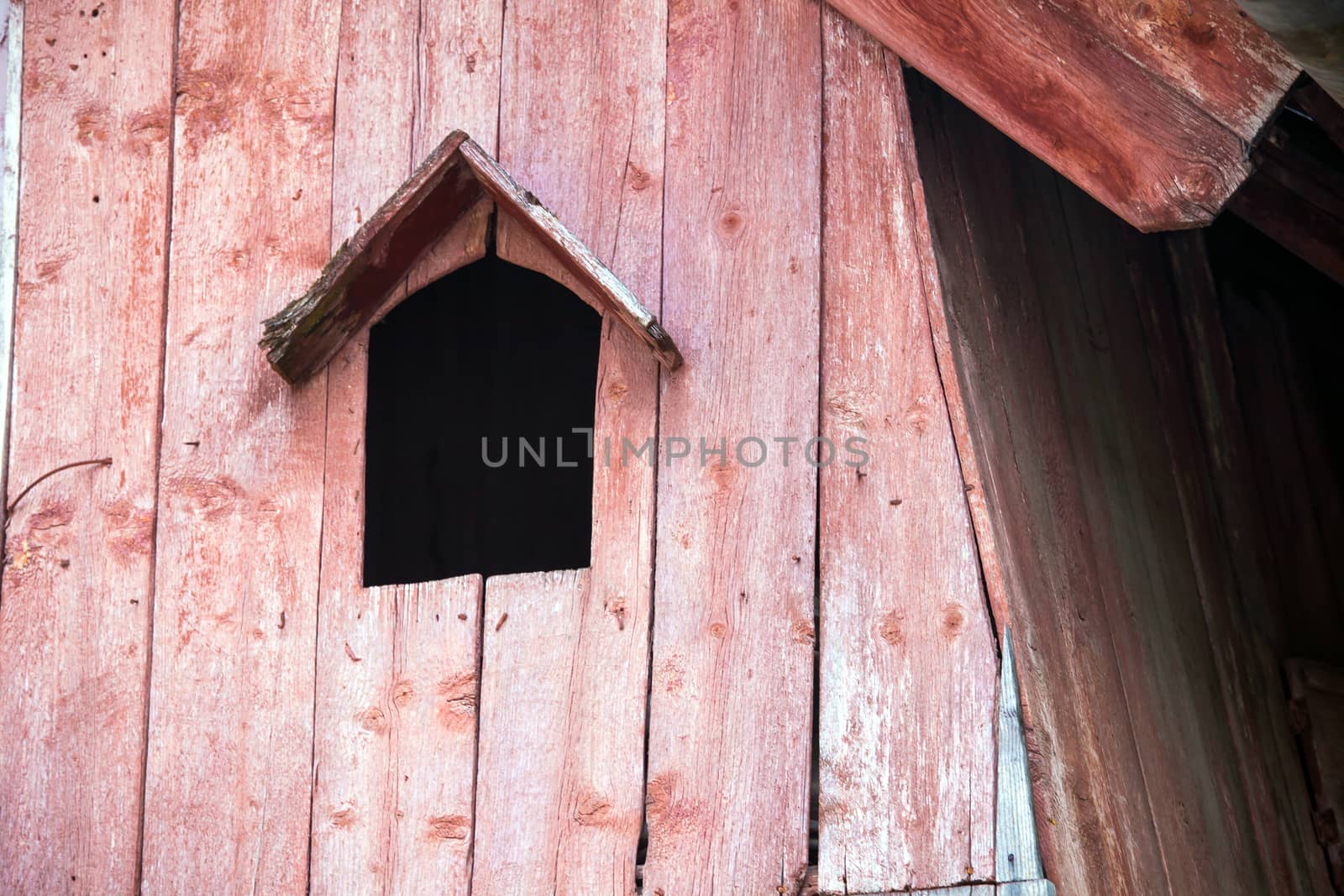 Turda, Romania - June 23, 2013: Typical pink bird house on a wooden roof in Turda city, Romania