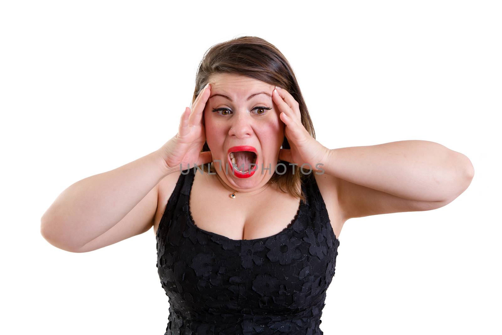 Terrified woman wearing low-cut sleeveless black top while holding her head with both hands as a gesture of panic and shock, isolated portrait with copy space on white