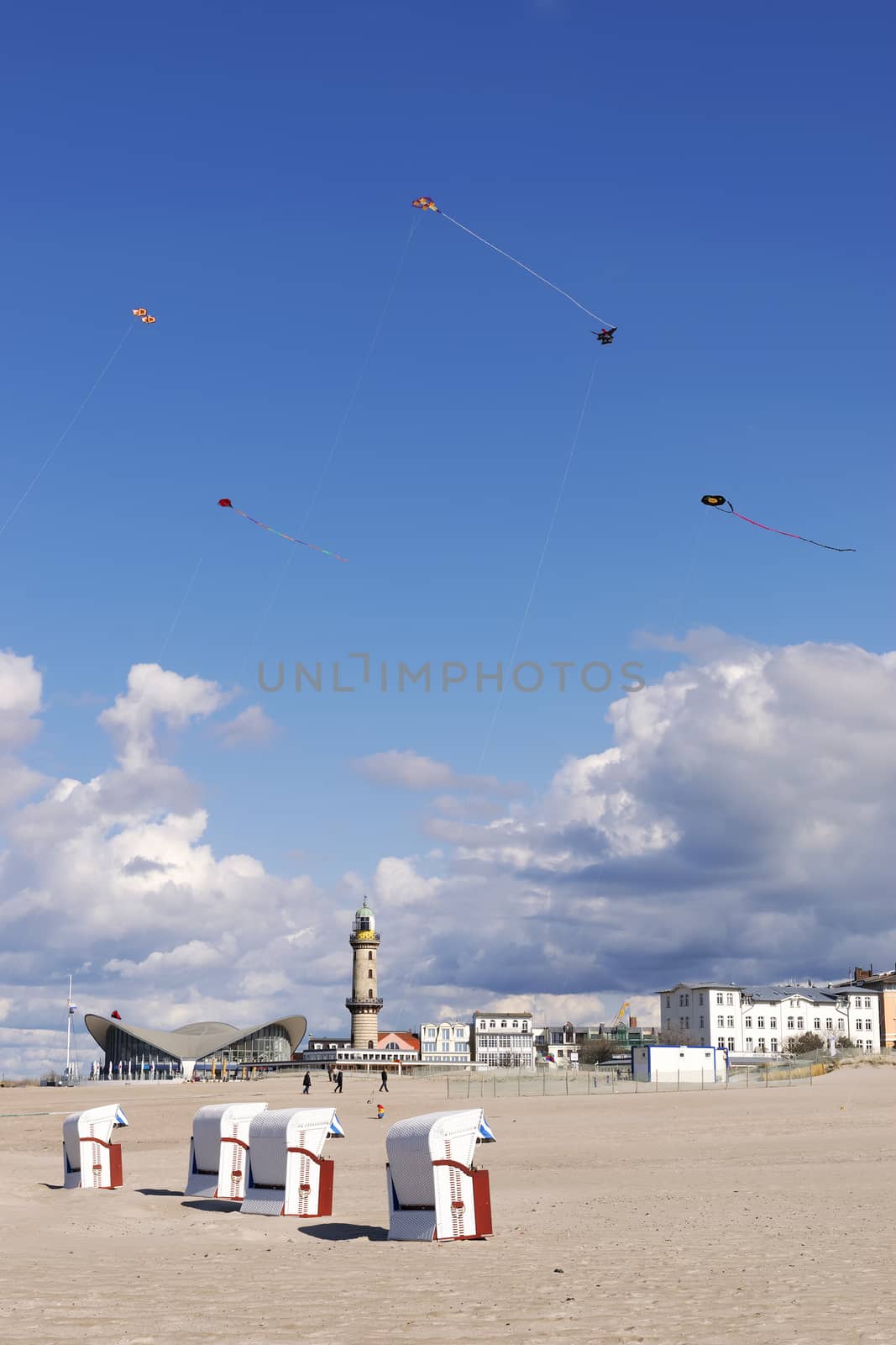 Image of sandy beach of Warnemunde with beach chairs and Lighthouse, Germany