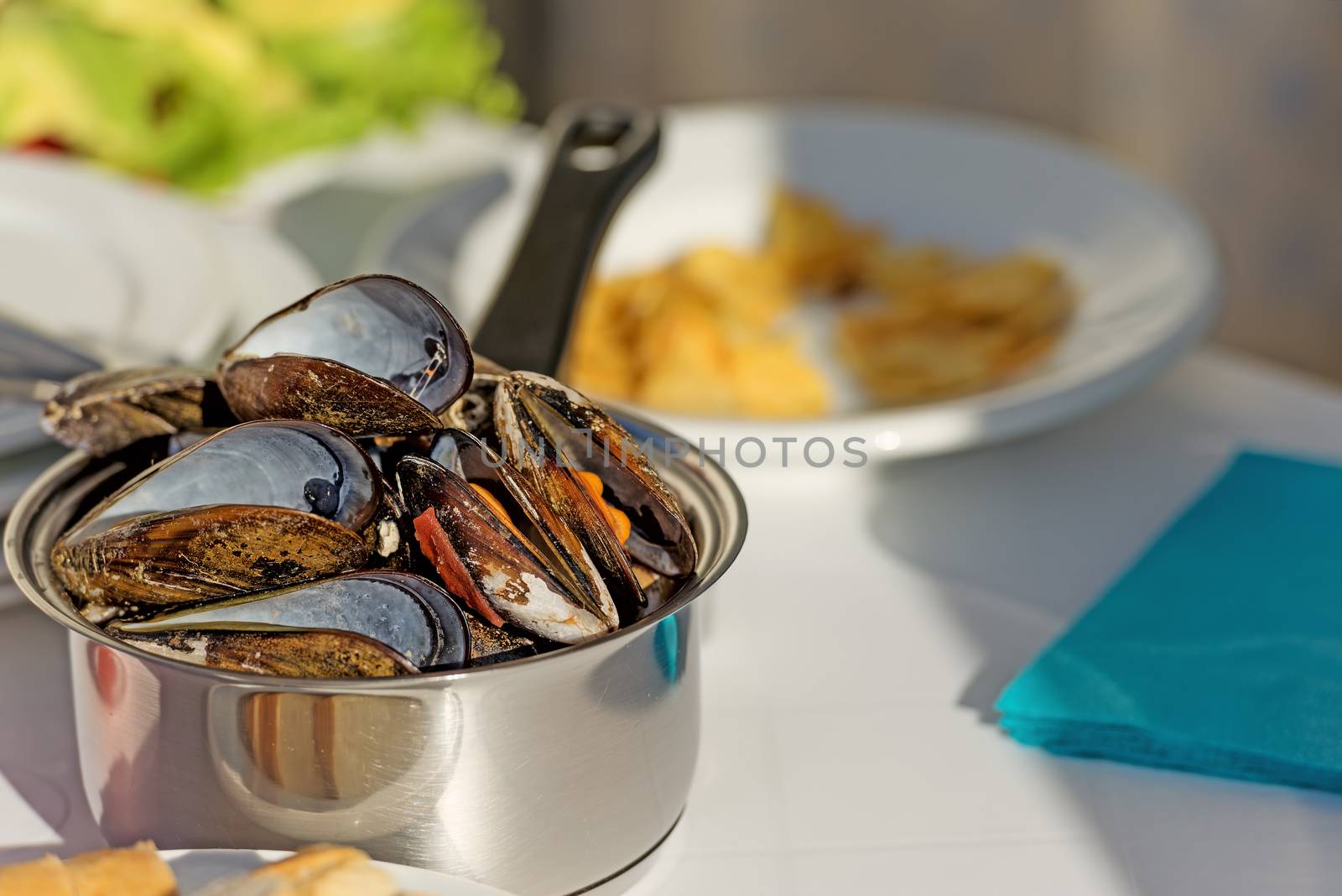 Pot of gourmet mussels garnished with fresh herbs by Nanisimova