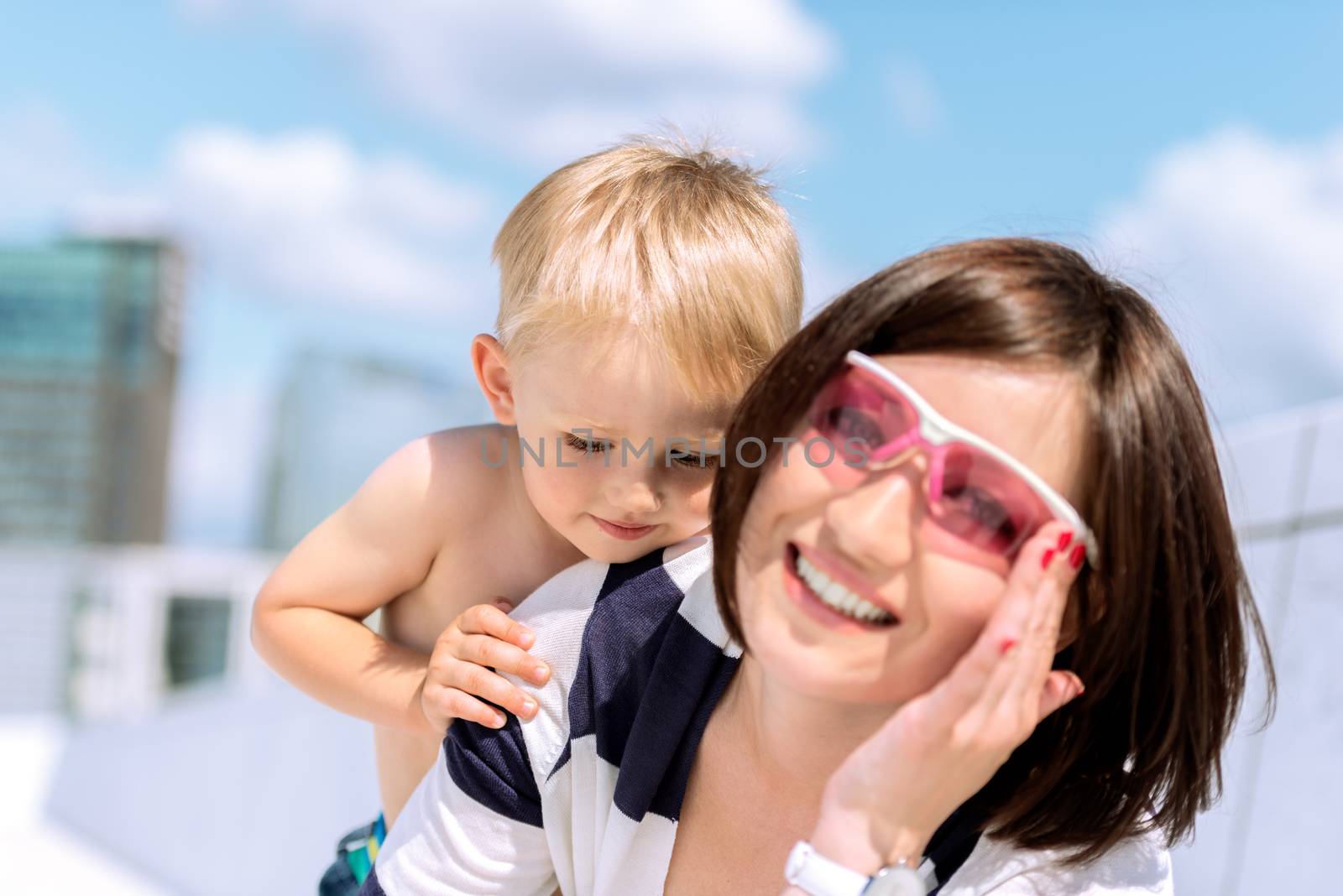 Lovely portrait of a mother and son outdoor having fun by Nanisimova