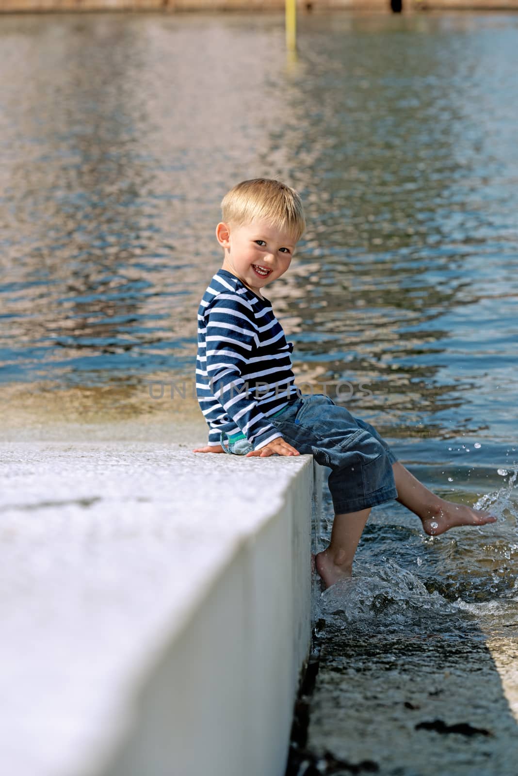 Little preschool boy posing on shore outdoors