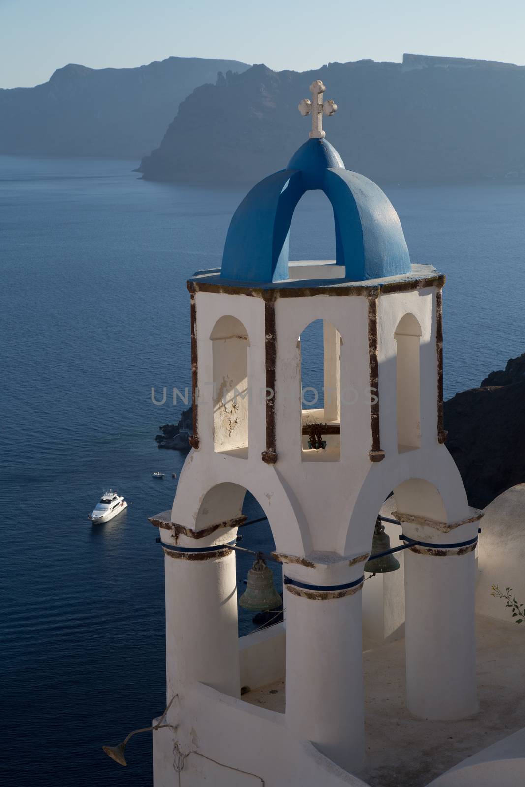 Blue domes and their bell tower in Oia. Santorini