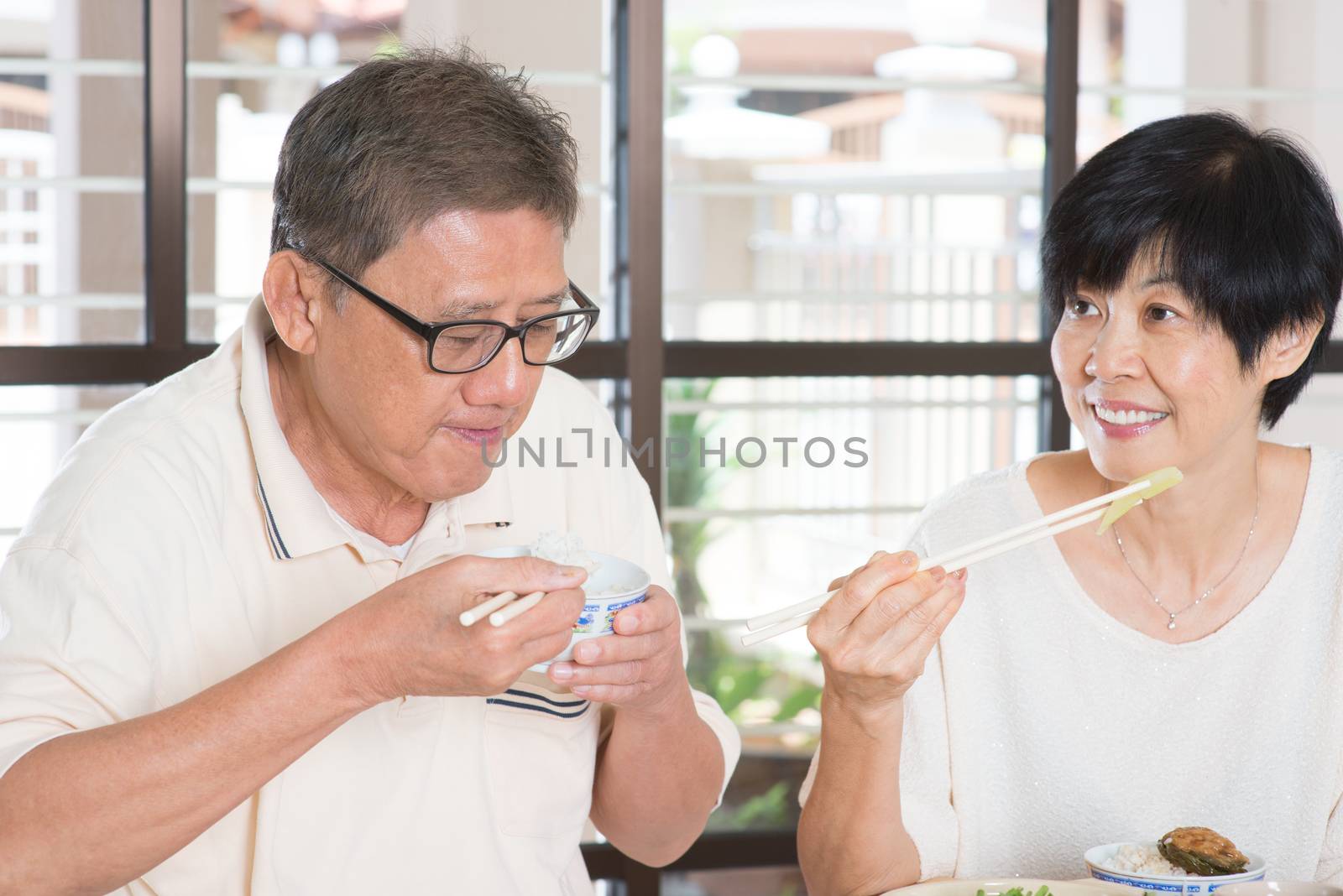 Asian Senior Couple Eating Meal At Home. Family living lifestyle.