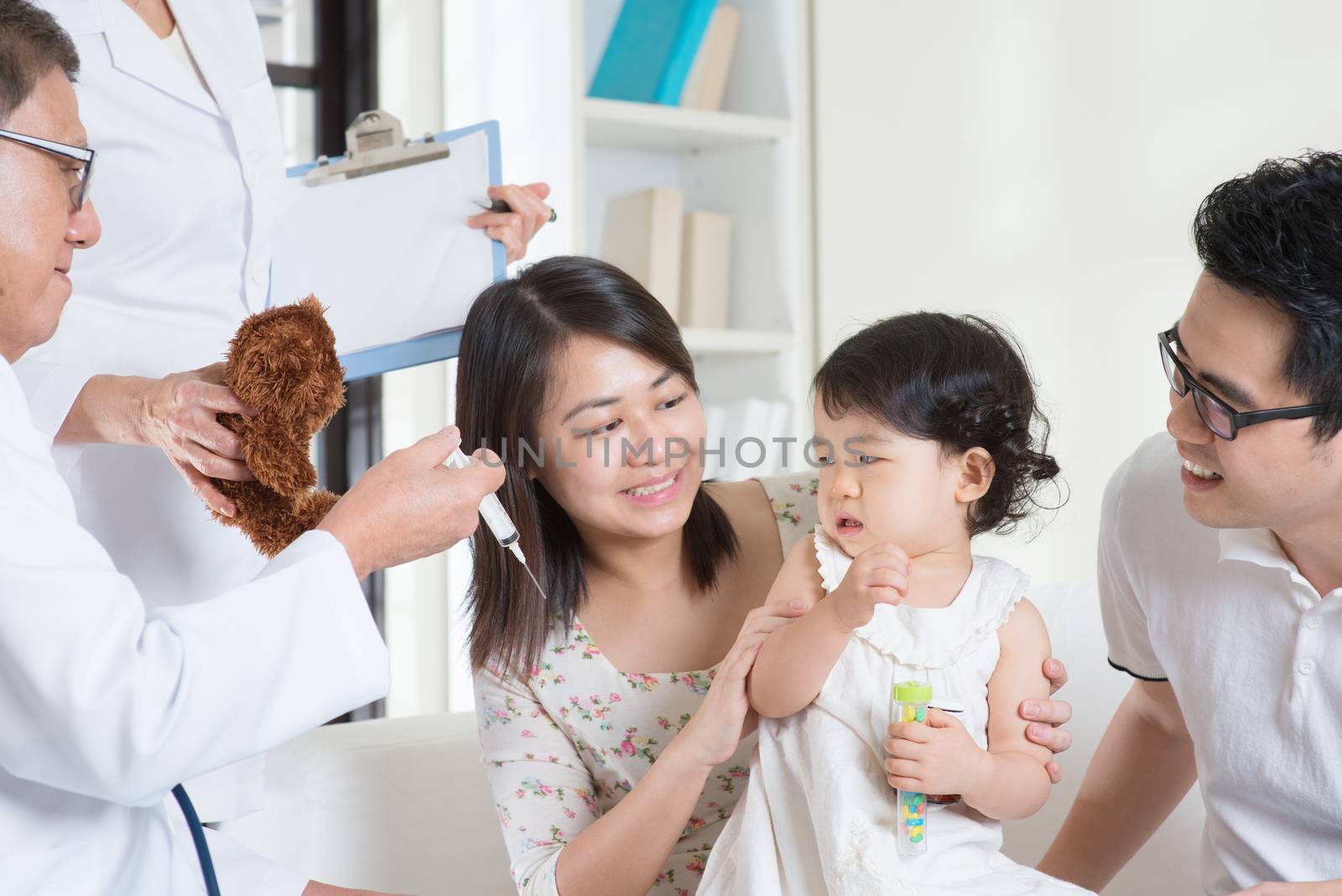 Child vaccination. Family doctor vaccines or injection to baby girl. Pediatrician and patient.
