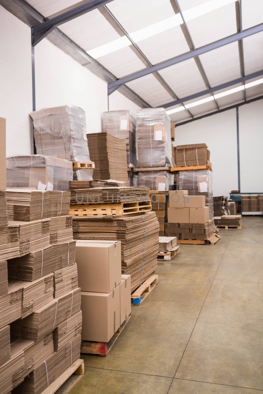 Many stack of cardboard boxes in a large warehouse