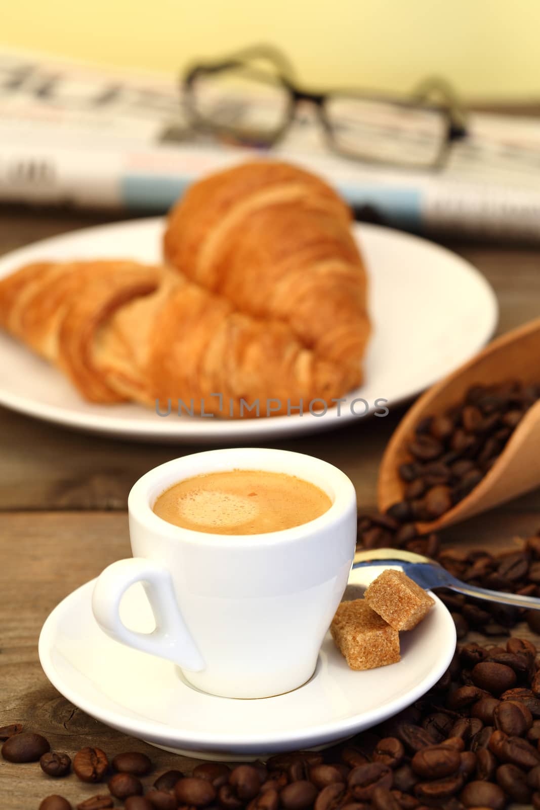 Coffee and croissants on wooden table shallow dof