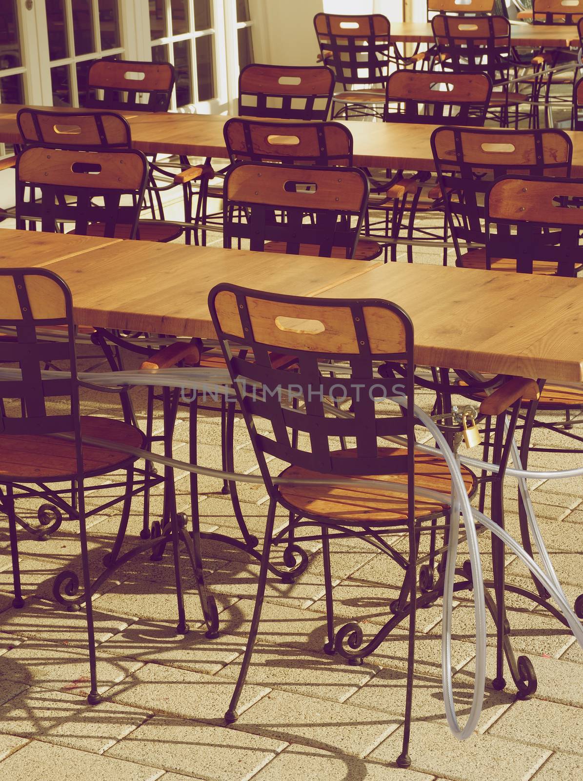 Wooden Chairs with Locking Cables in Still Closed Street Cafe Outdoors. Retro Styled